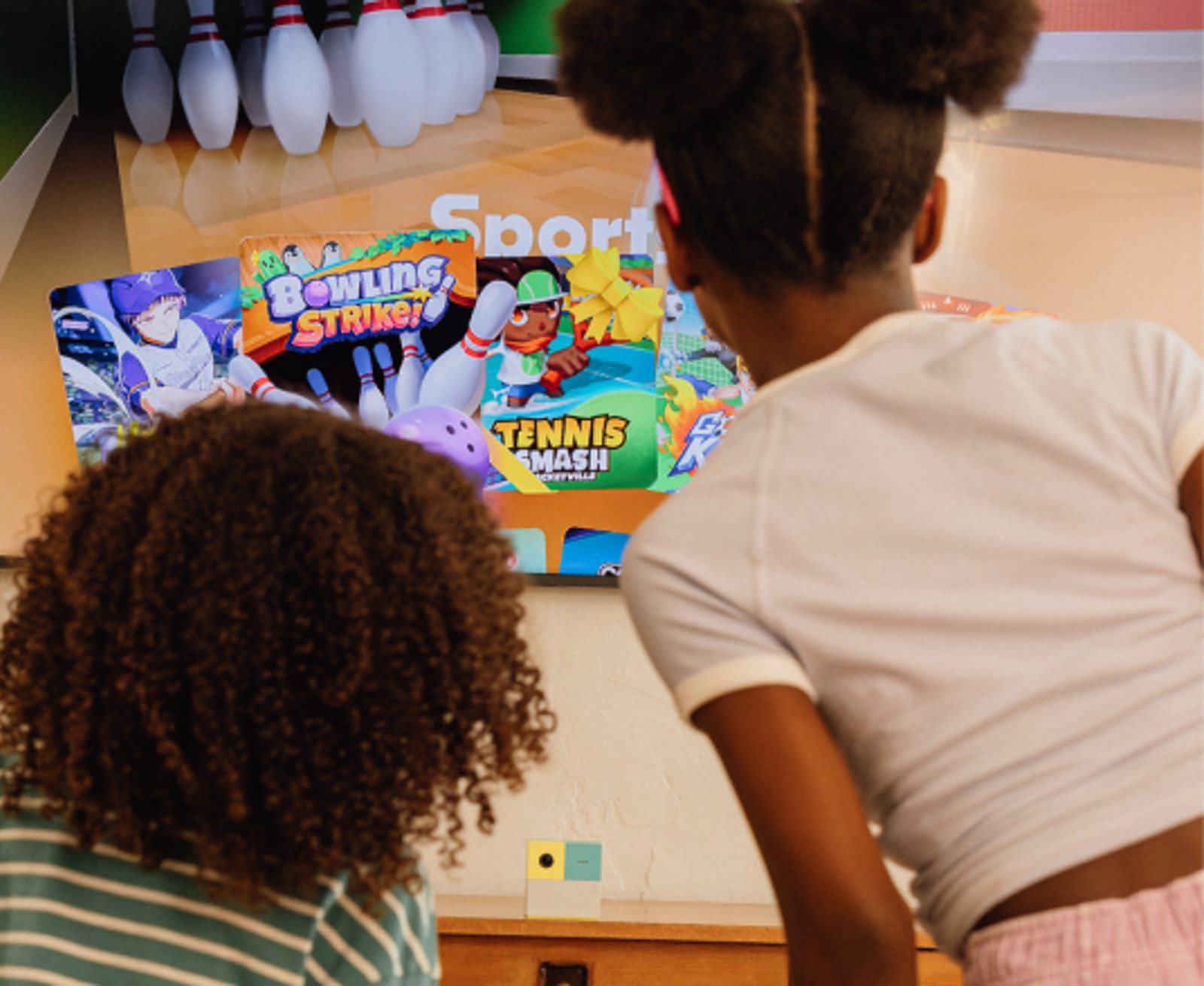 2 girls looking at game content on the tv.