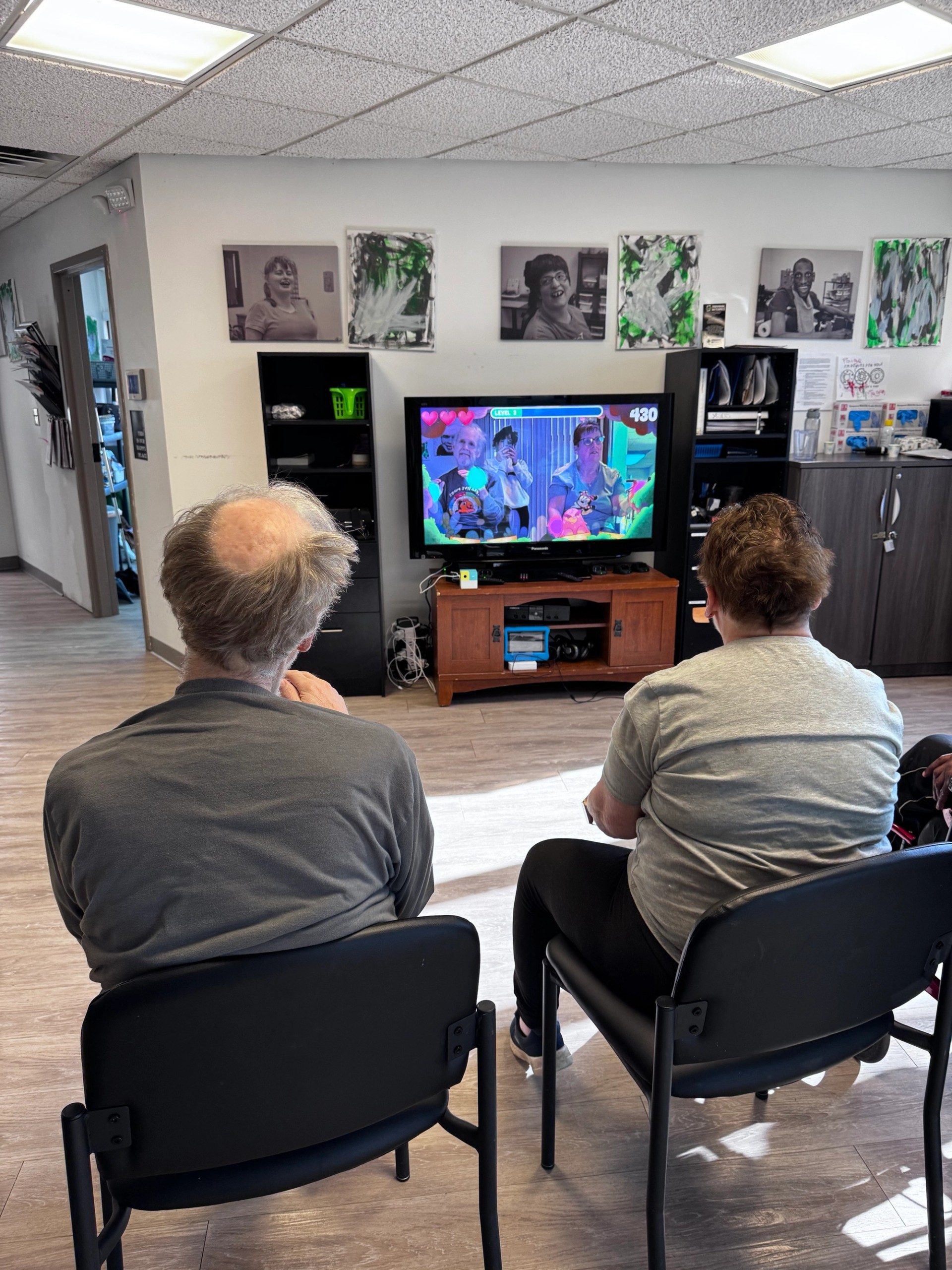Two men playing Nex Playground while seated at Individual Outcomes, an adult day center.