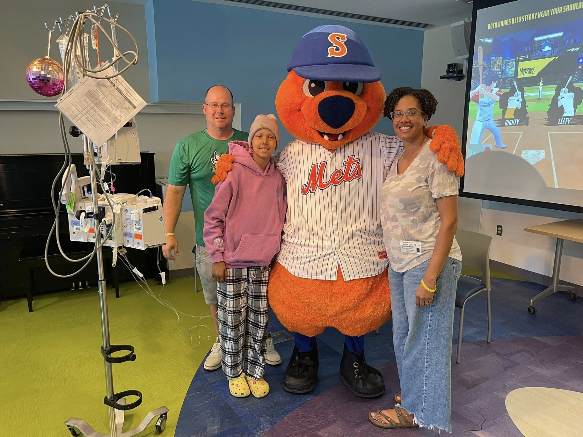 Syracuse Mets mascot visiting a patient for the Nex Playground for Good event at Golisano Children's Hospital.