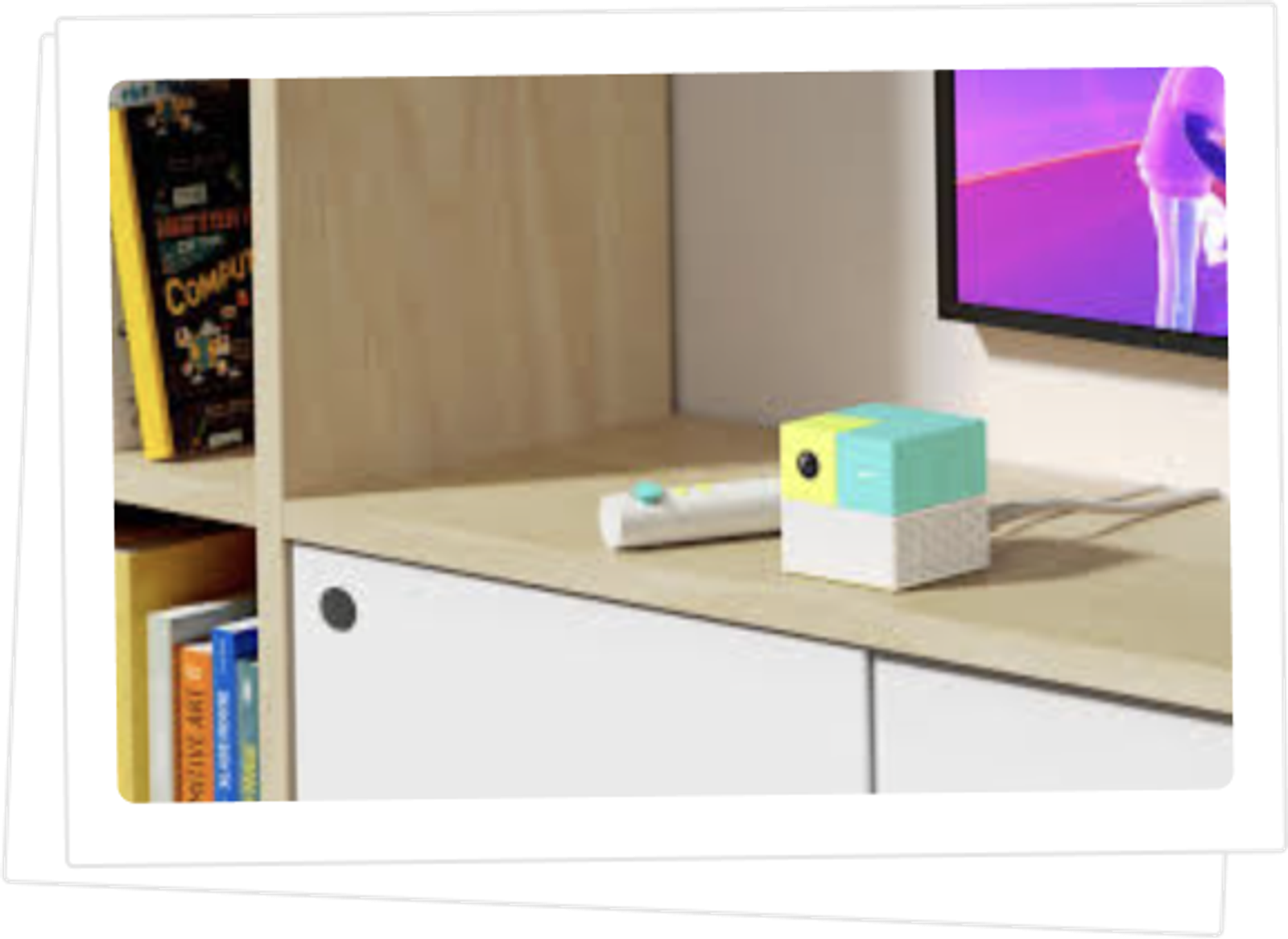 The Nex Playground console and remote on a living-room shelf beside a TV.