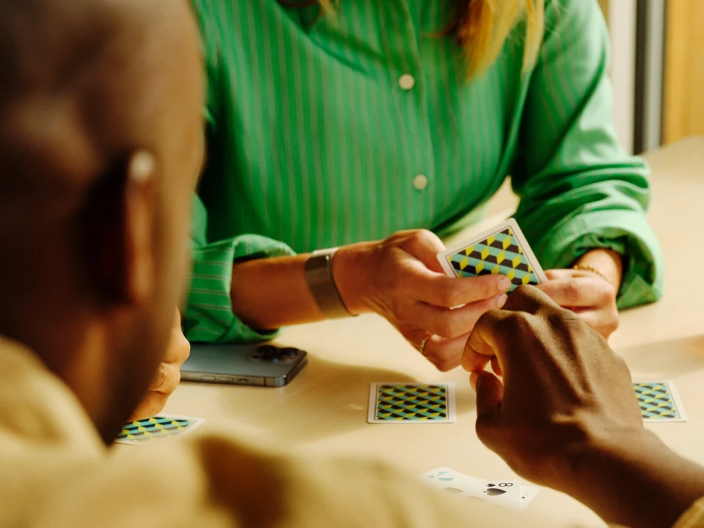 To personer spiller kort ved et bord
