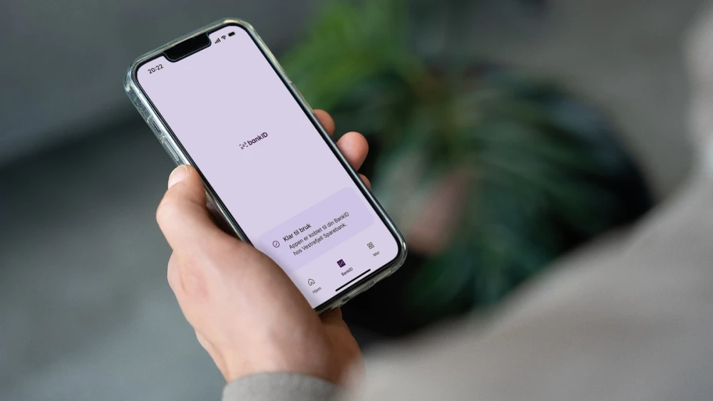 En hånd holder en mobil med BankID-appen