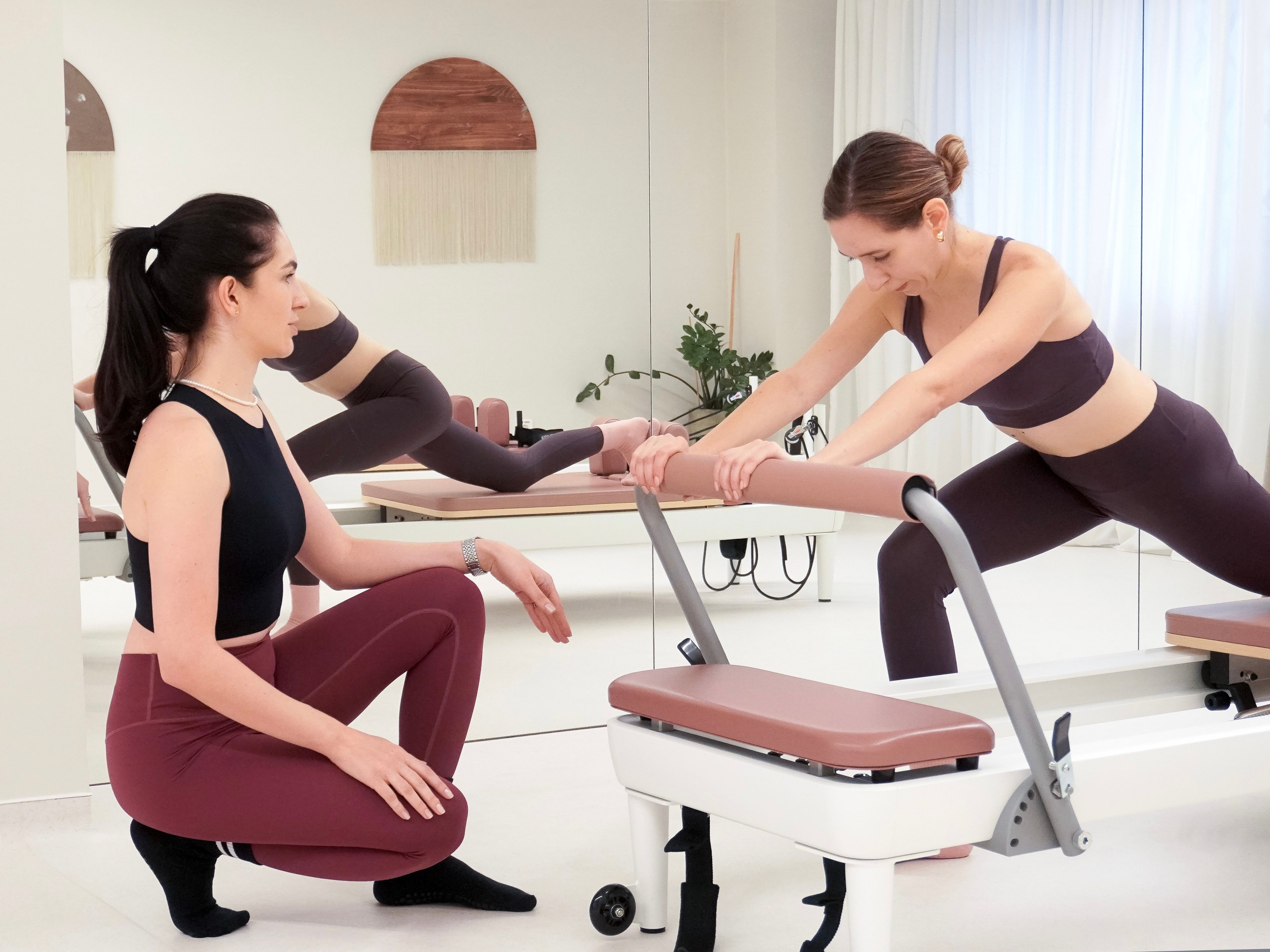 Instructor de Pilates care ghidează participantul