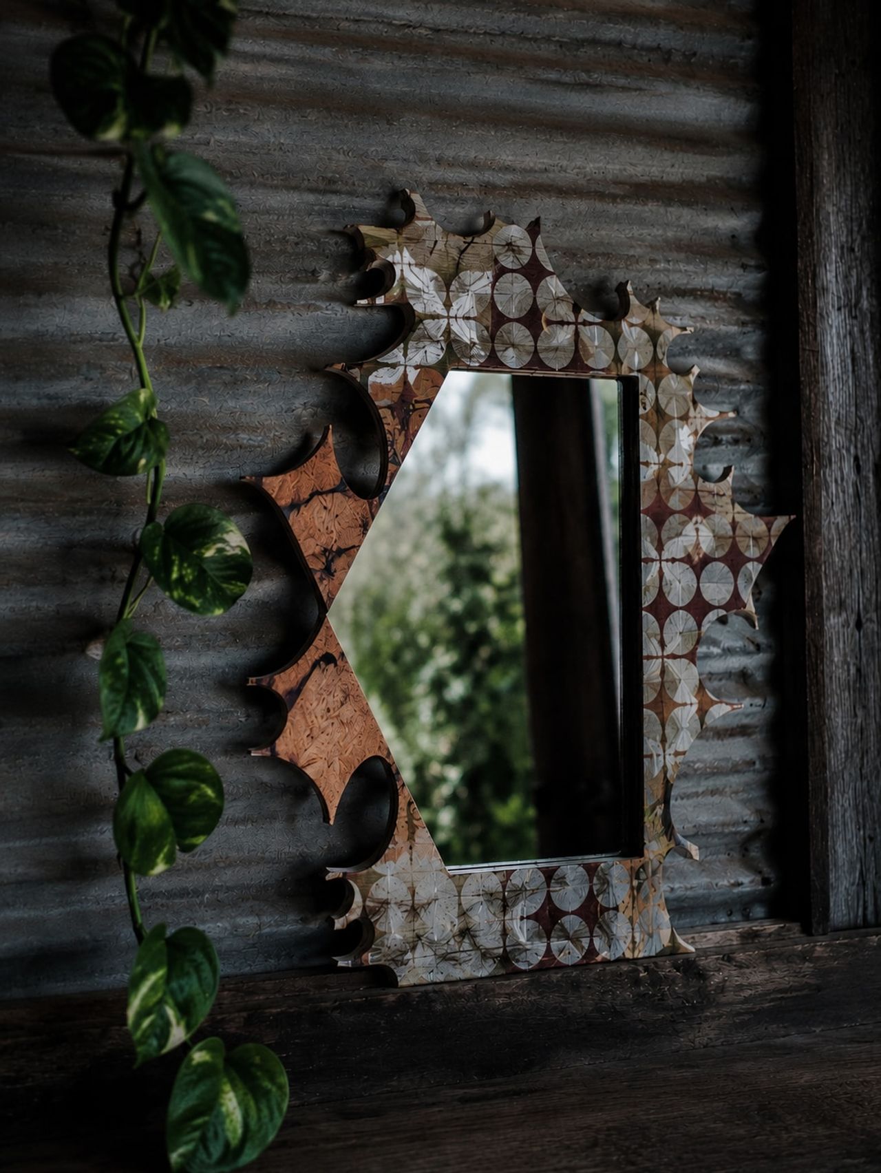 A handmade mirror on a corrugated iron wall