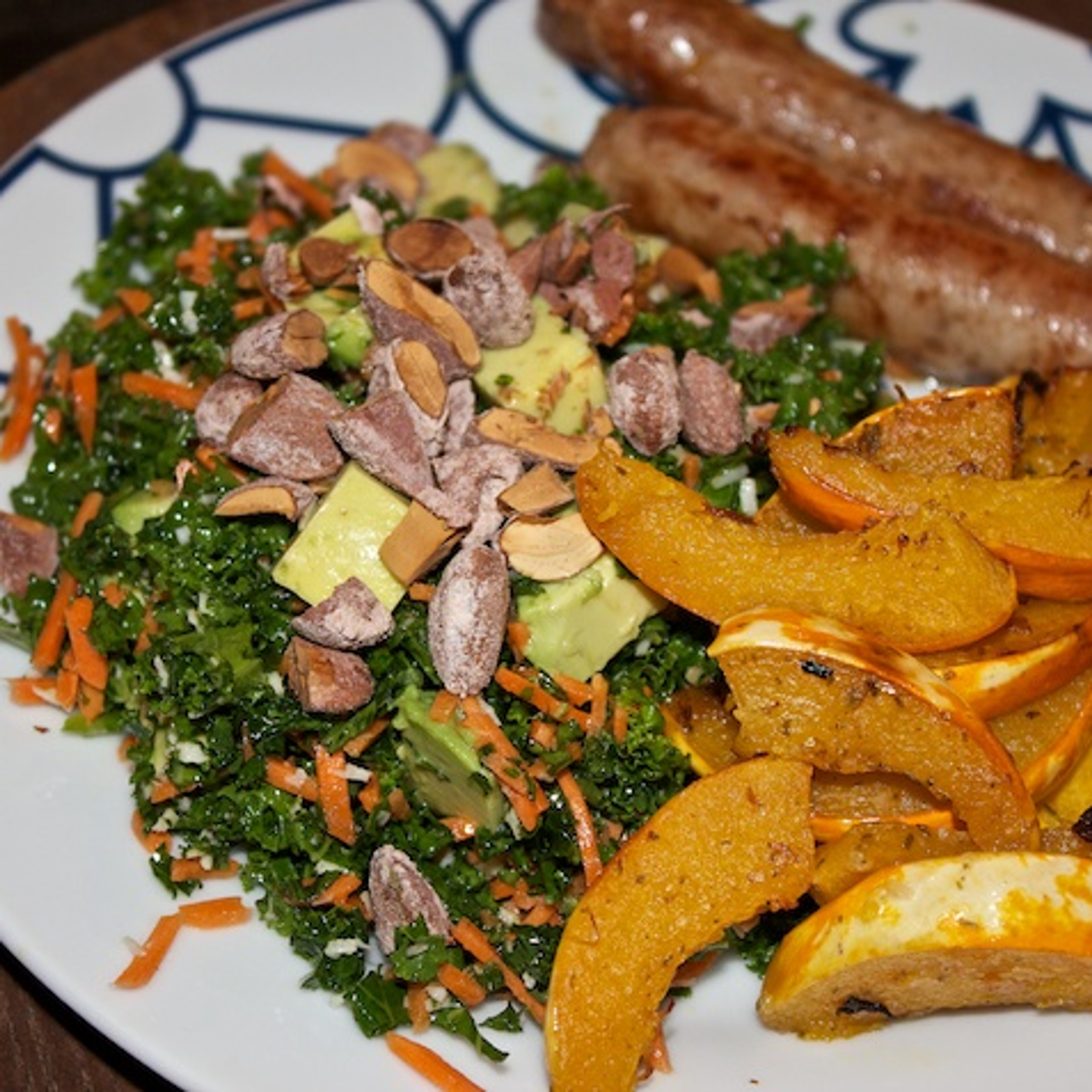 Fennikelpølser, hvidløgsbagt græskar og grønkålssalat med gulerod, avocado og saltmandler