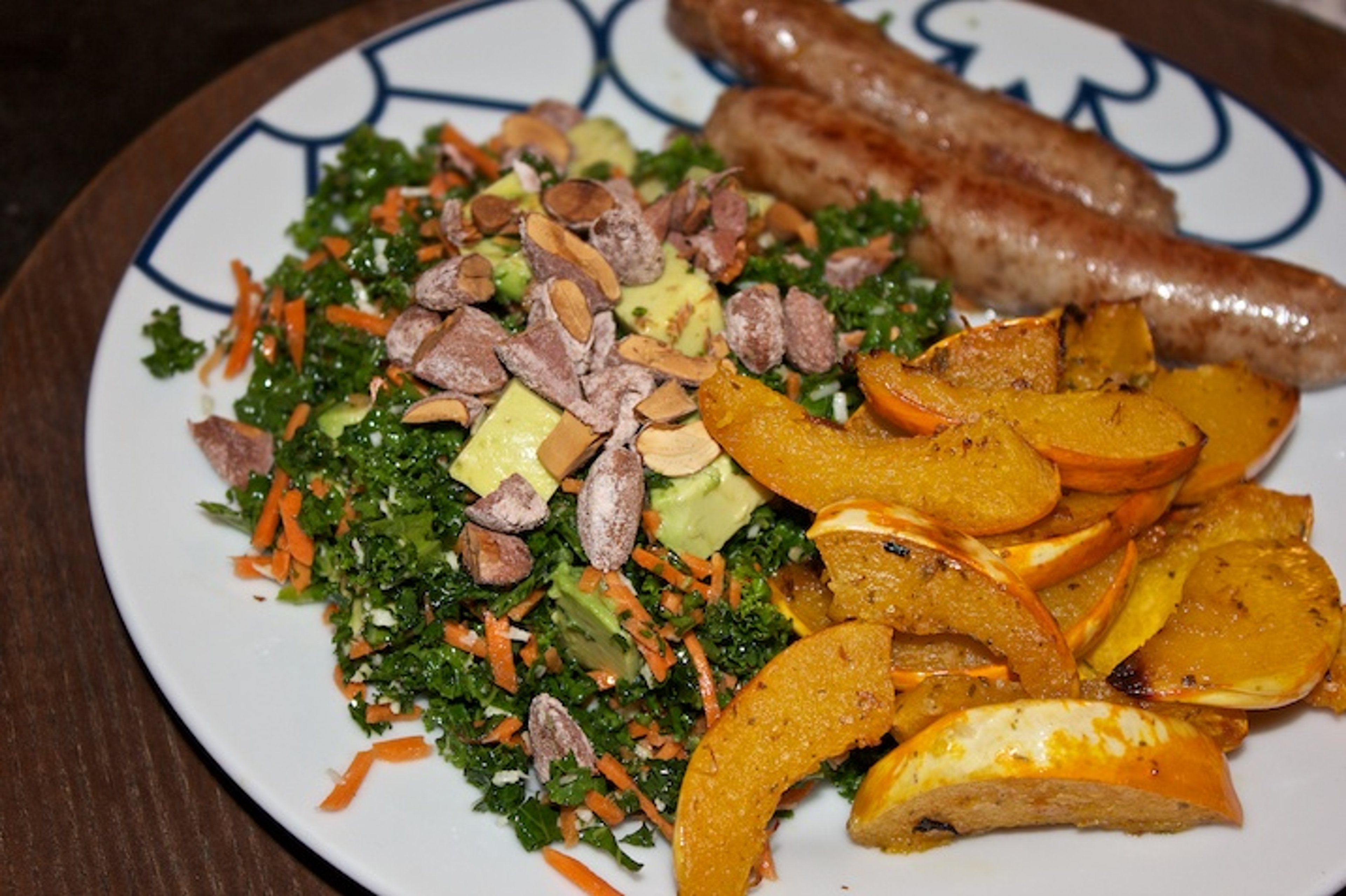 Fennikelpølser, hvidløgsbagt græskar og grønkålssalat med gulerod, avocado og saltmandler