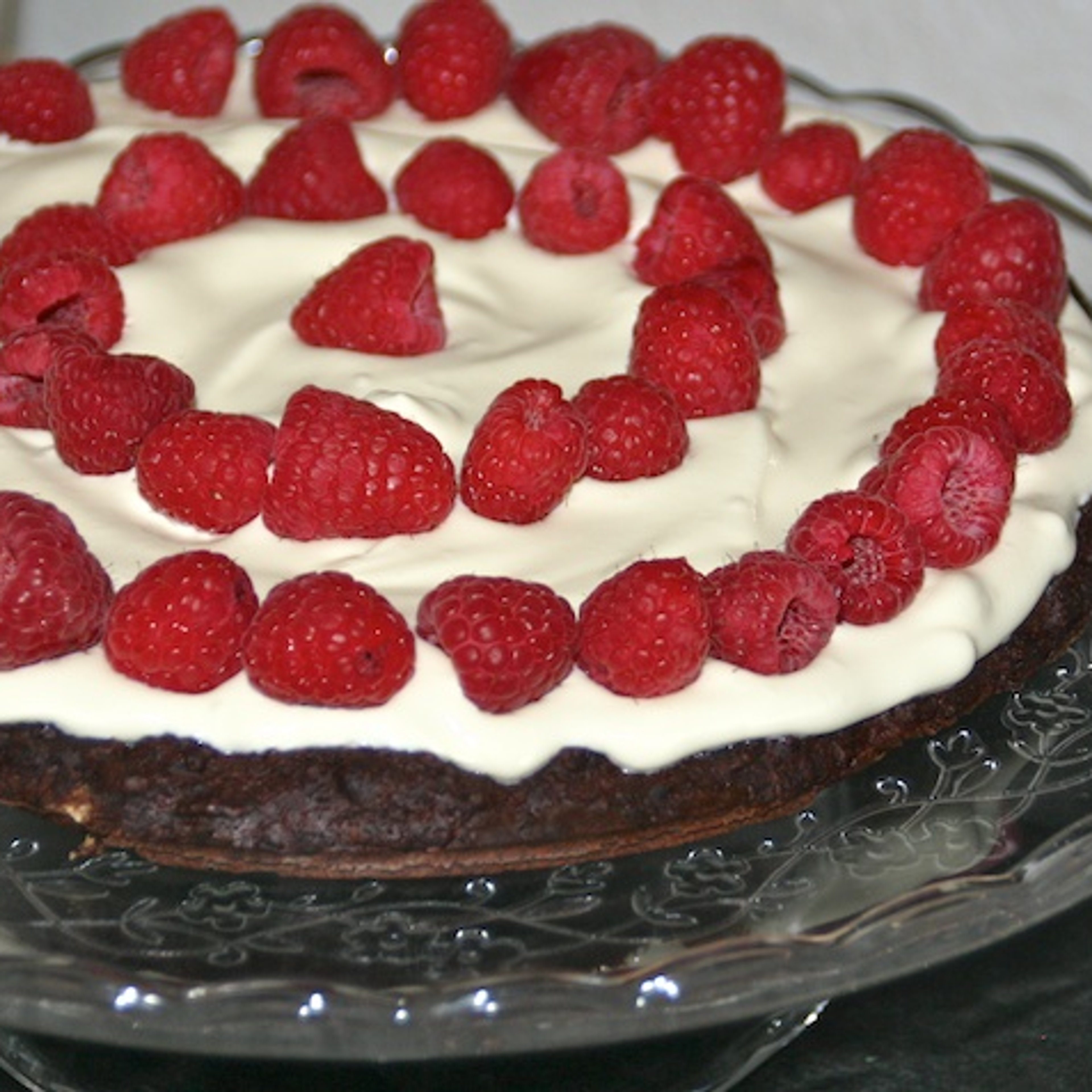 Chokoladekage med mandler, creme og friske hindbær