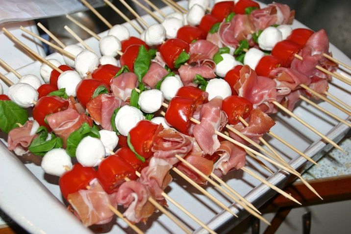 Insalata caprese con prosciutto e olio di pesto su un bastone - eller tomatsalat med skinke og pestoolie på pind