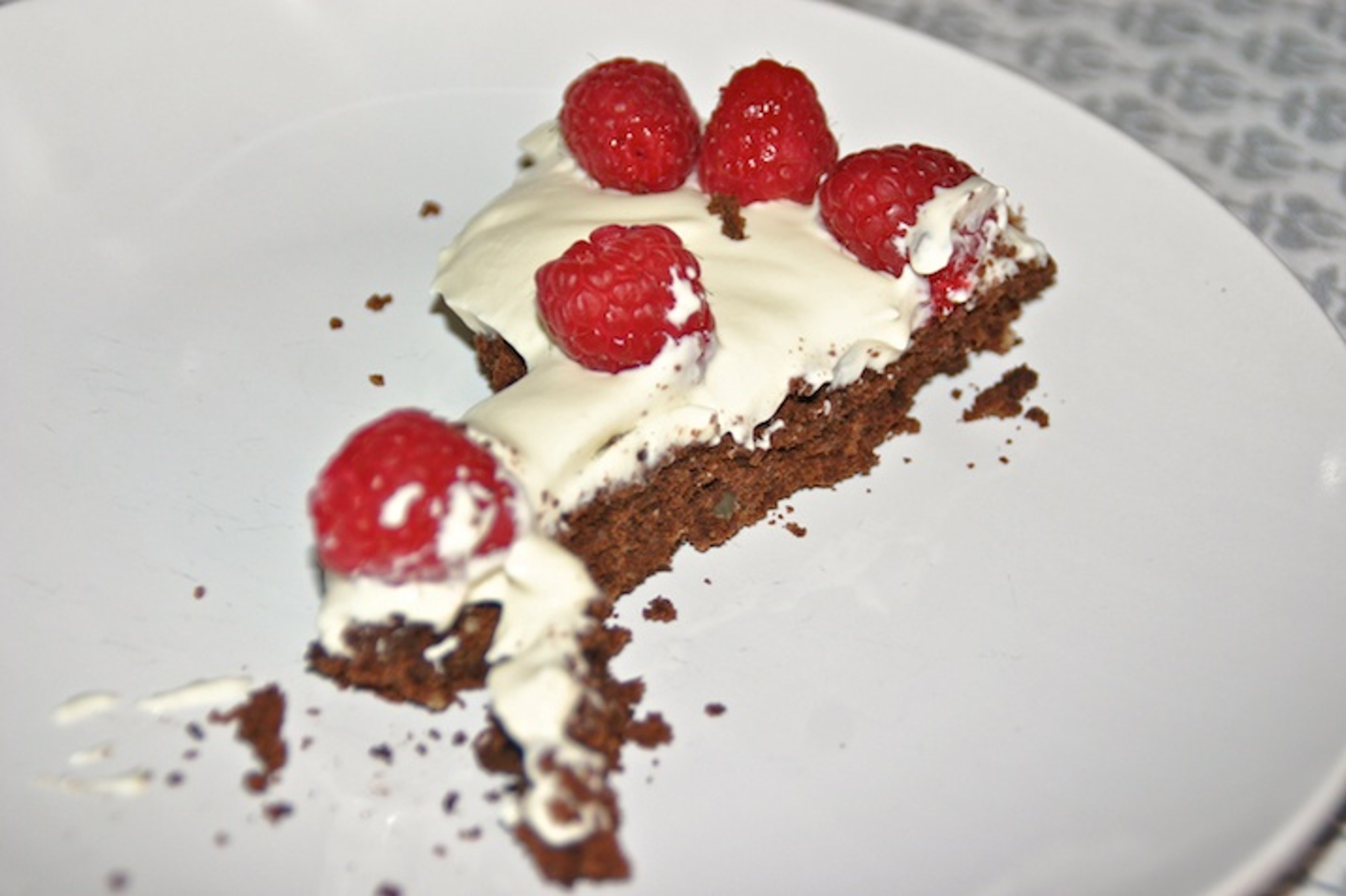 Chokoladekage med mandler, creme og friske hindbær