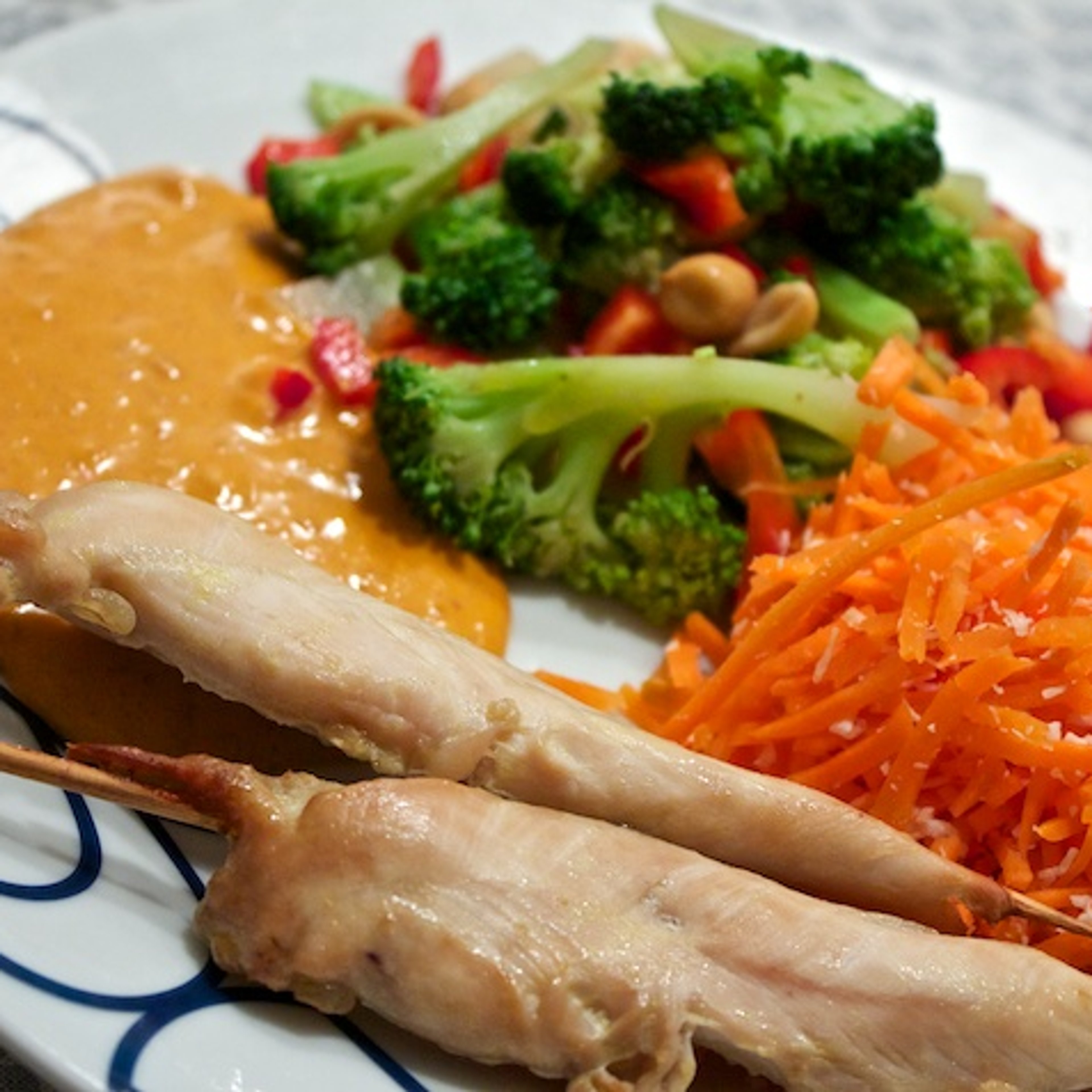 Satay-kyllingespyd med spicy peanutsauce, asiatisk broccolisalat og kokos-råkost