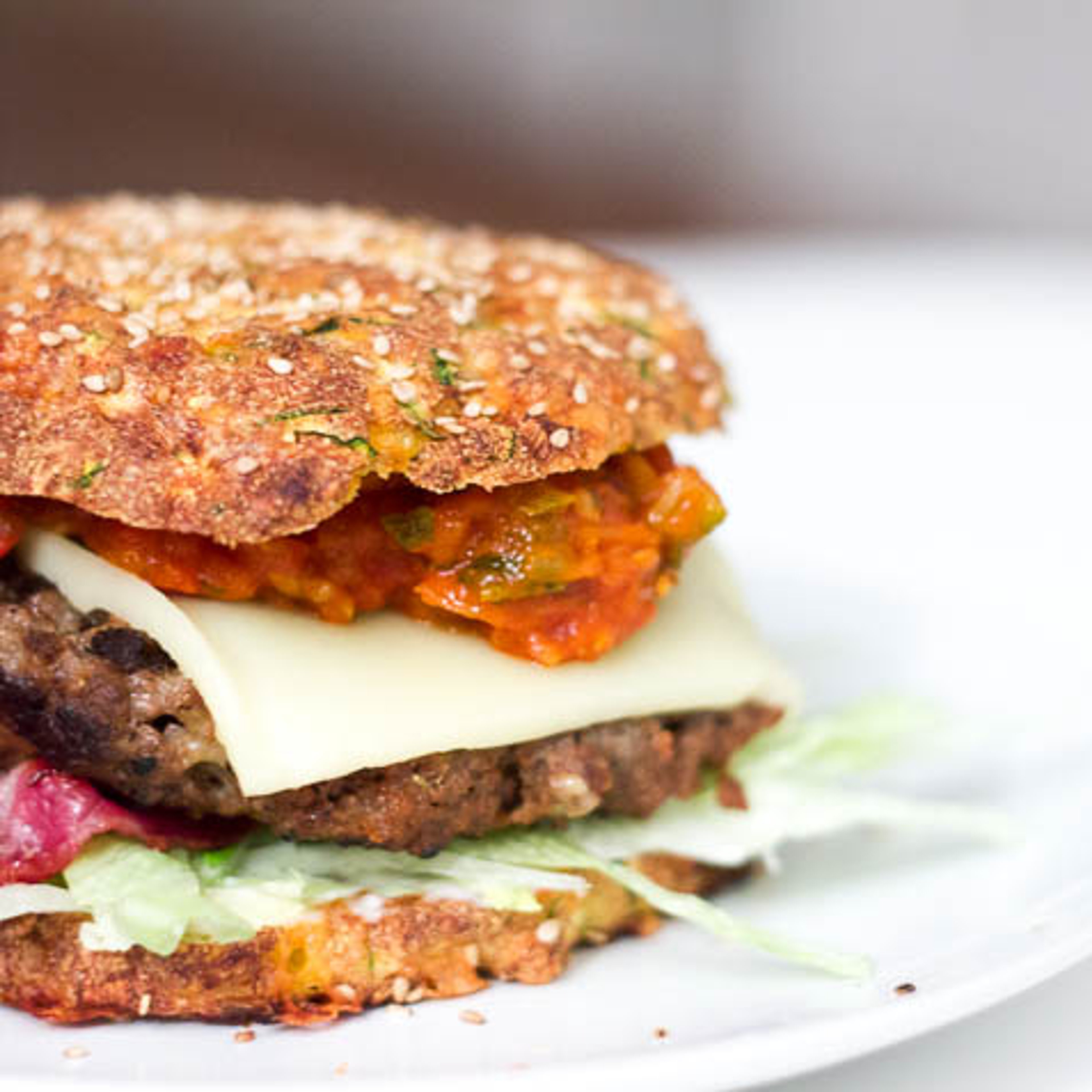 Cheeseburger med tomatrelish og bacon i burgerbolle med squash og ost