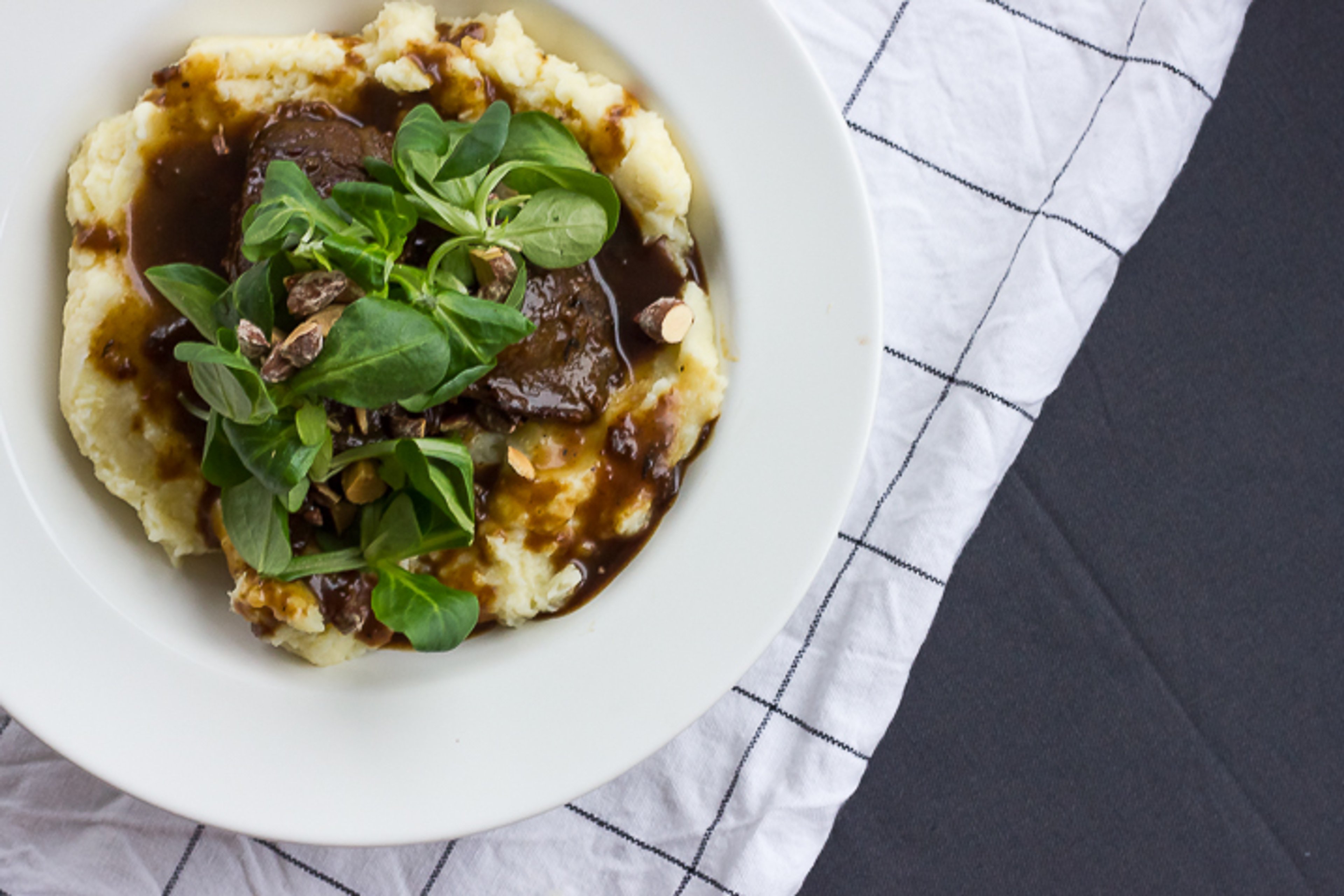 Braiserede svinekæber i øl og æblemost med grov mos og saltmandler