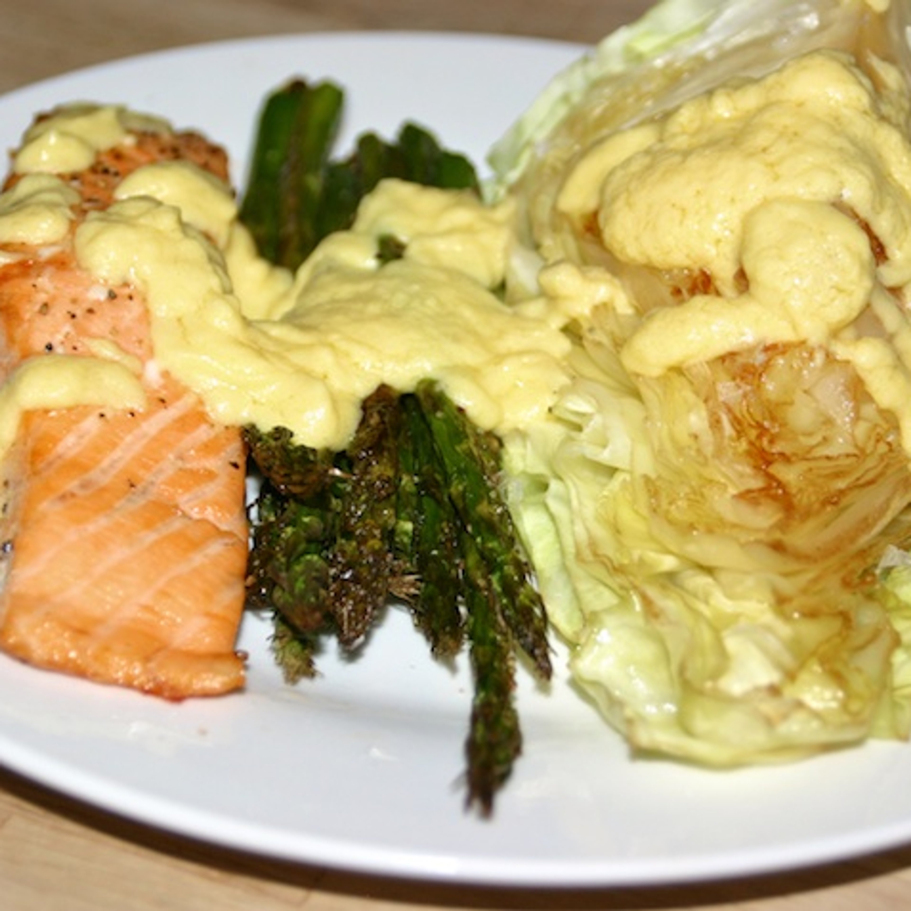 Laks med grønne asparges, smørstegt spidskål og hollandaise