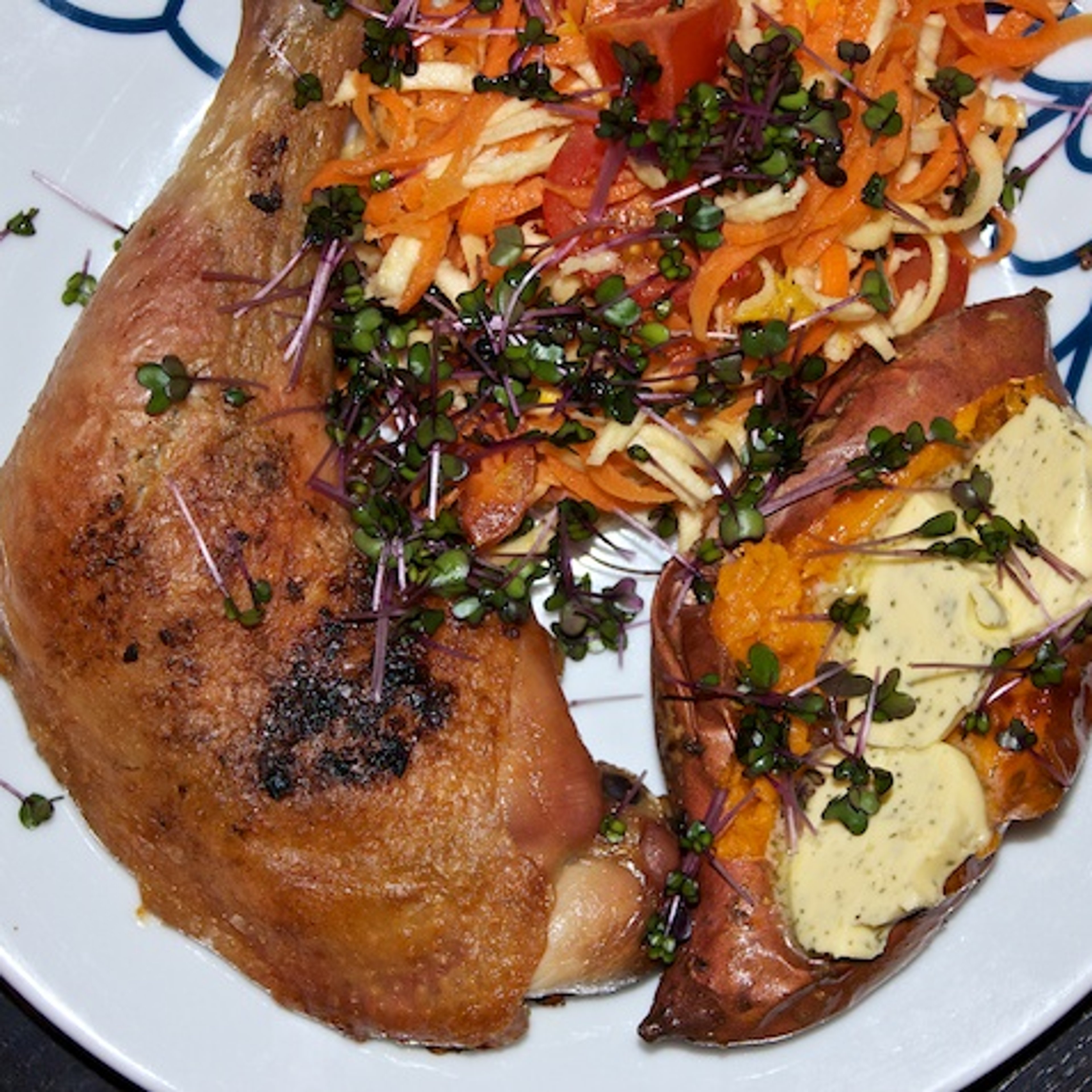 Langtidsstegte kyllingelår med bagt sød kartoffel, hvidløgssmør og ingefær- og citrusmarinerede rødder