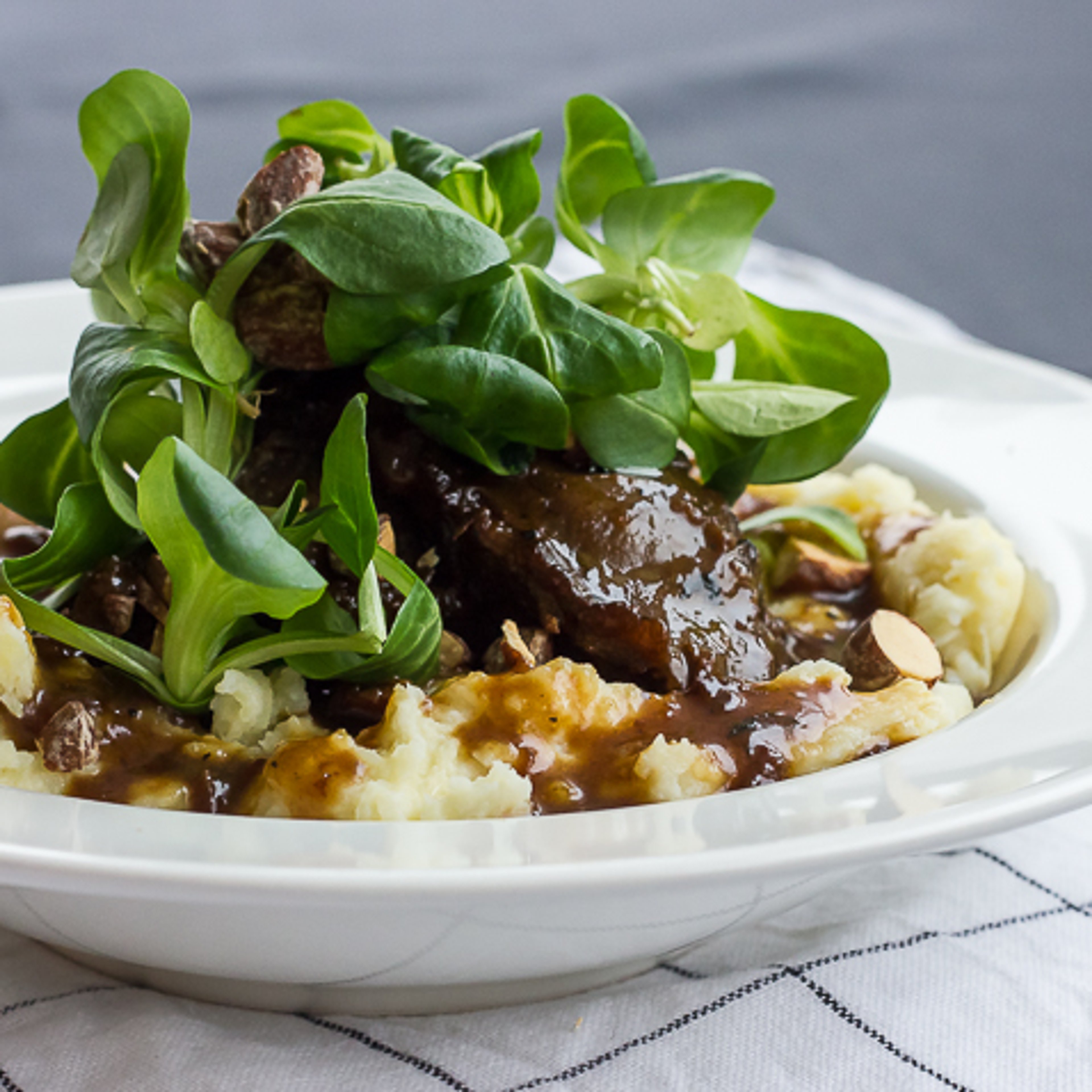 Braiserede svinekæber i øl og æblemost med grov mos og saltmandler