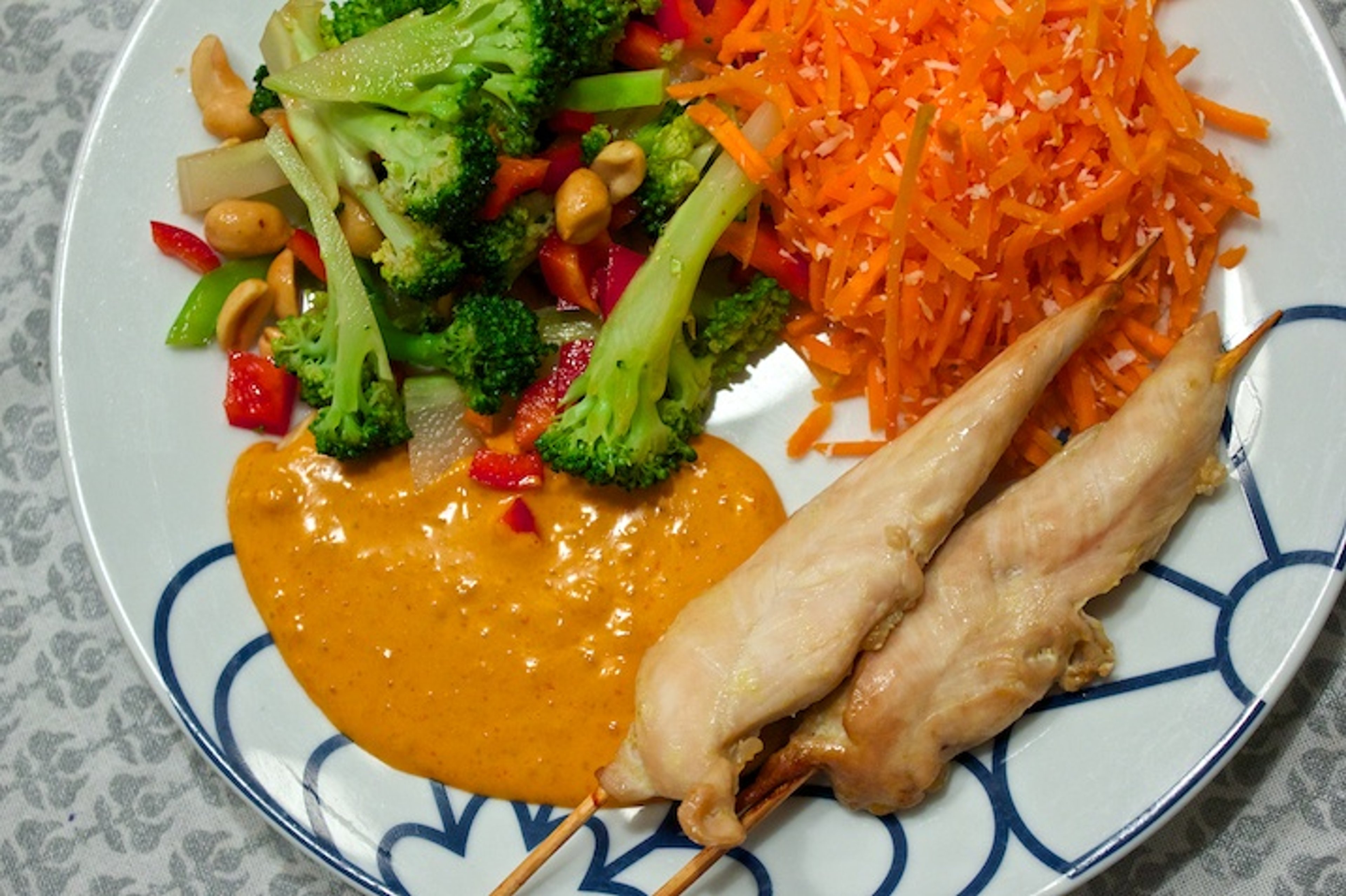 Satay-kyllingespyd med spicy peanutsauce, asiatisk broccolisalat og kokos-råkost