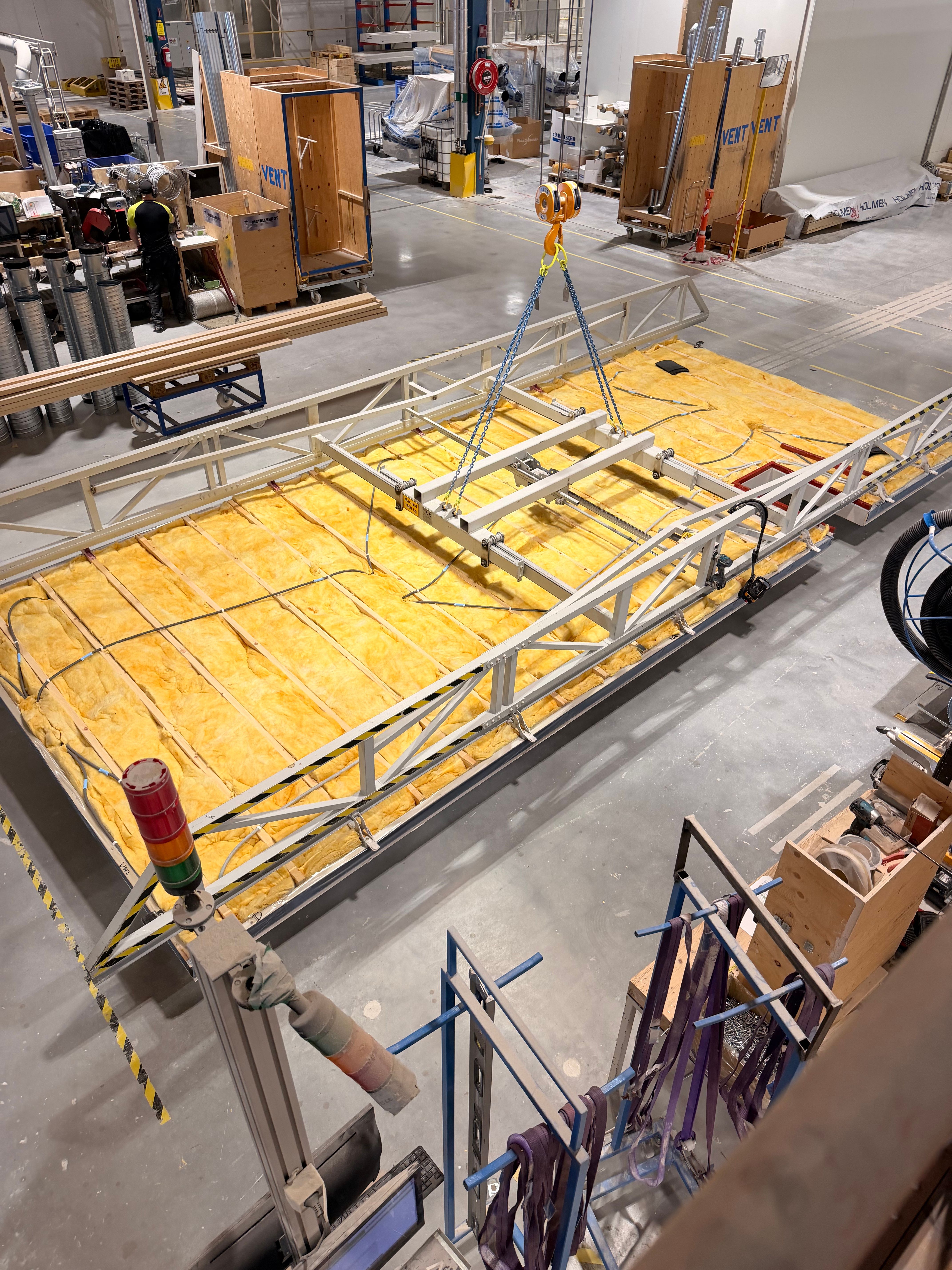 The Cassette Lift yoke lowered onto an insulated floor cassette at the Lindbäcks factory