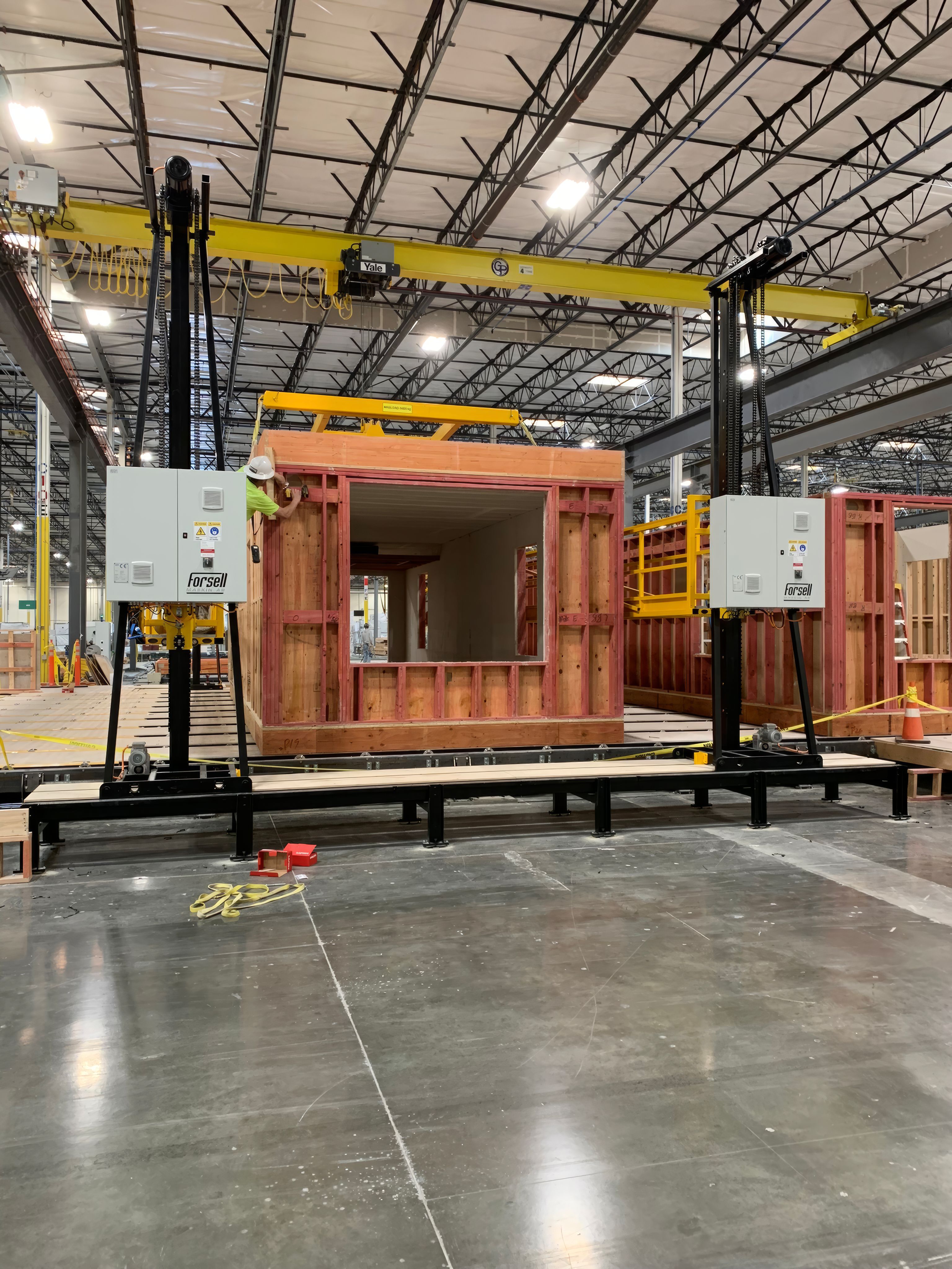 A Vertiaccess Rail platform beside a house module at the Volumetric Building Companies factory