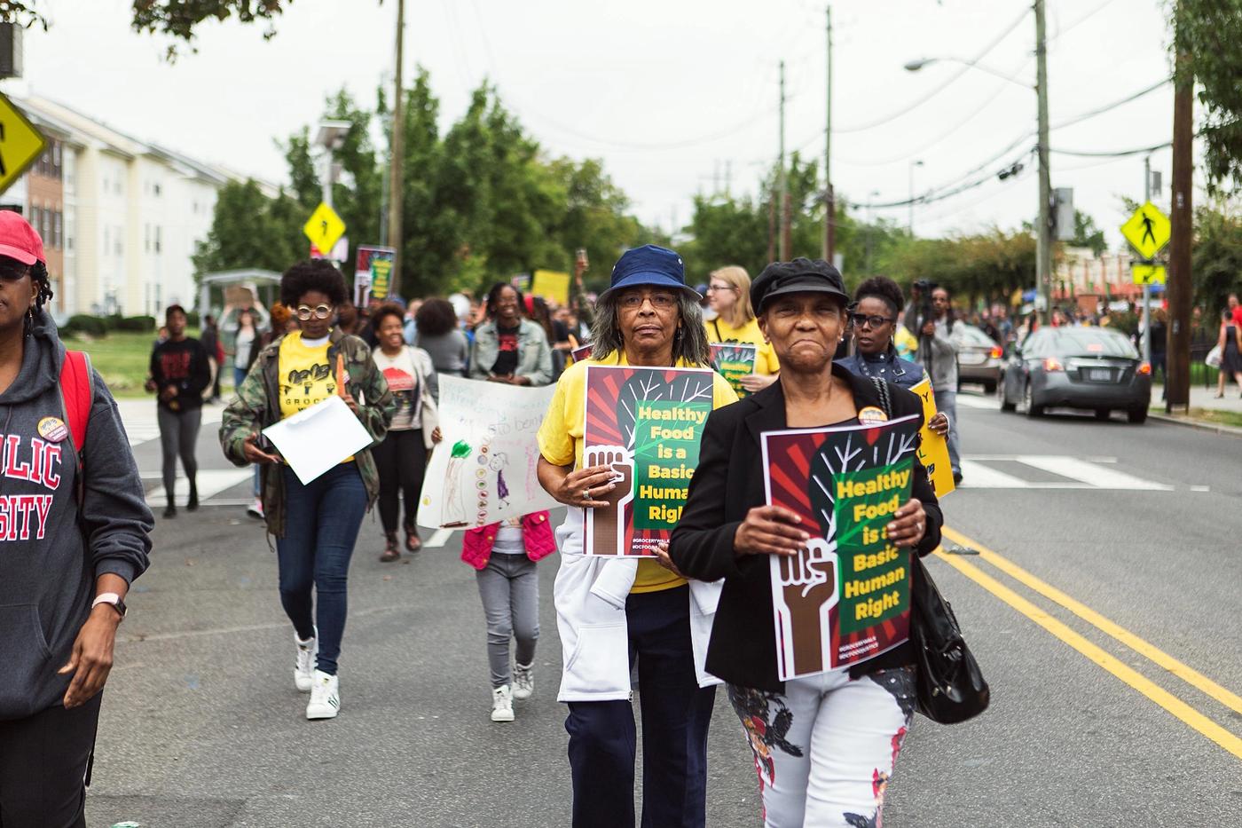 People marching with signs that read Healthy Food Is a Basic Human Right