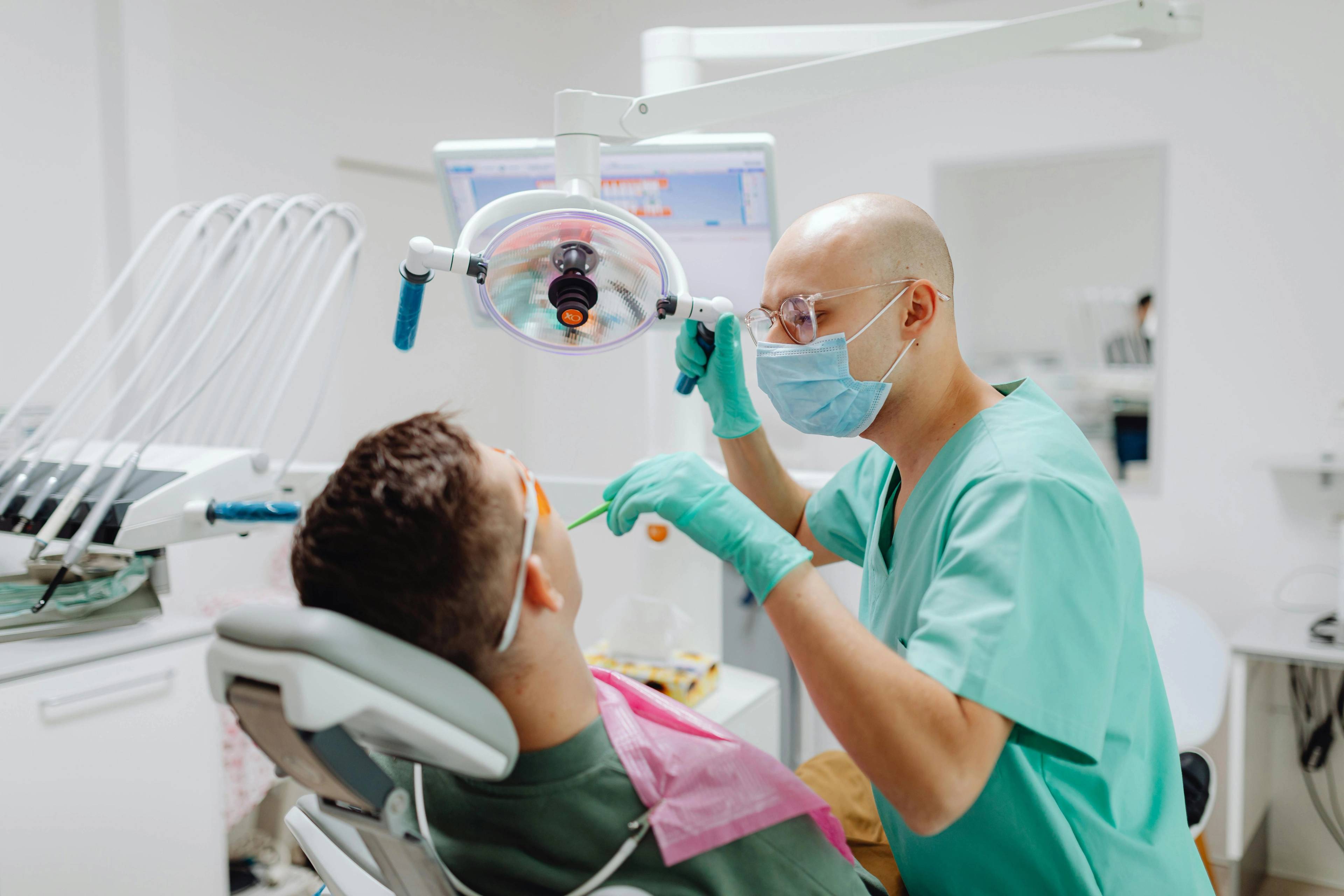 A stock photo of a dentist inspecting a patient's teeth