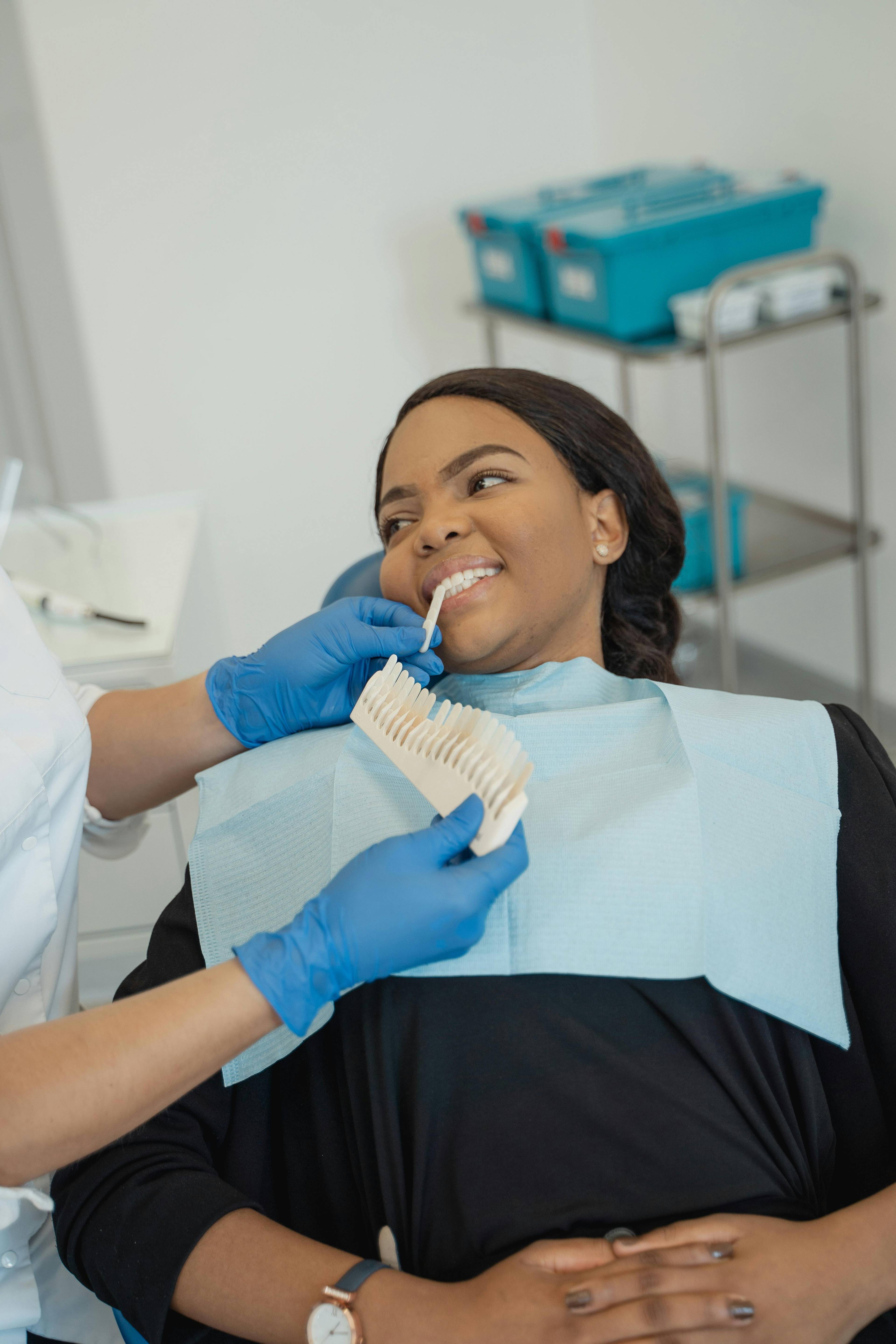 A stock photo of a patient having a tooth whitening model held up to her teeth