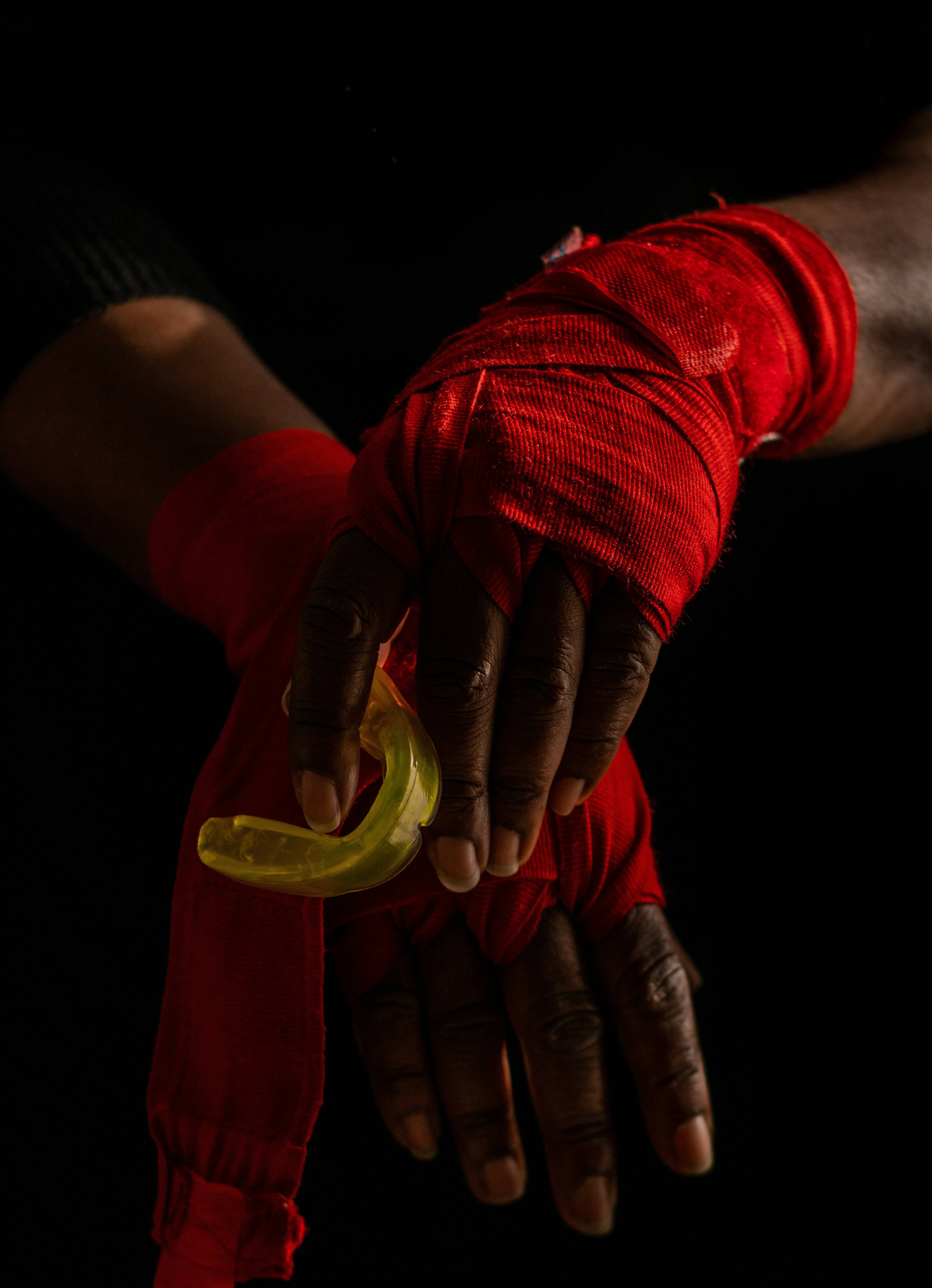 A photo of a person's hands wearing sports straps and holding a gumshield