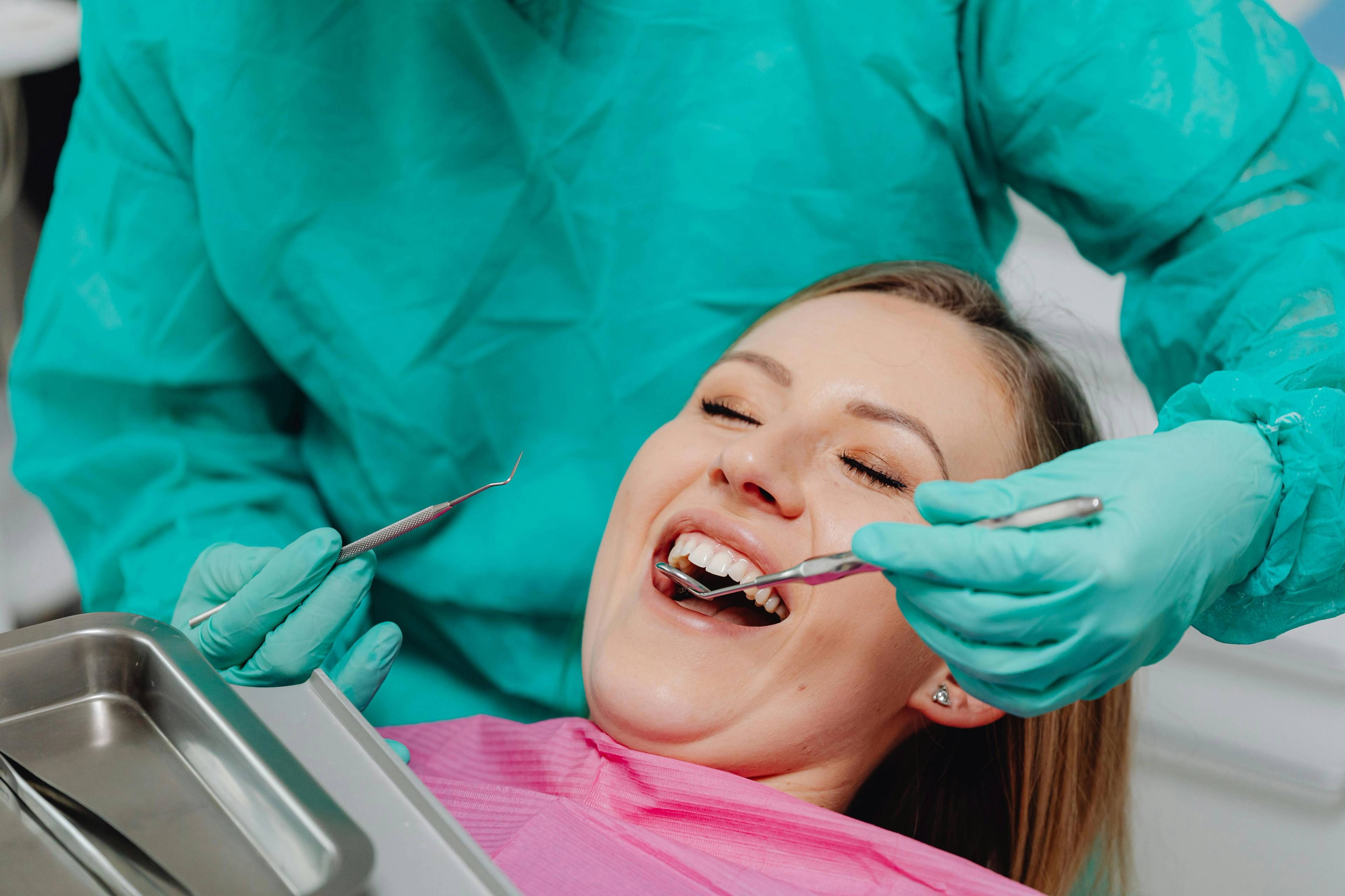 A stock photo of a patient having her teeth examined by a dentist