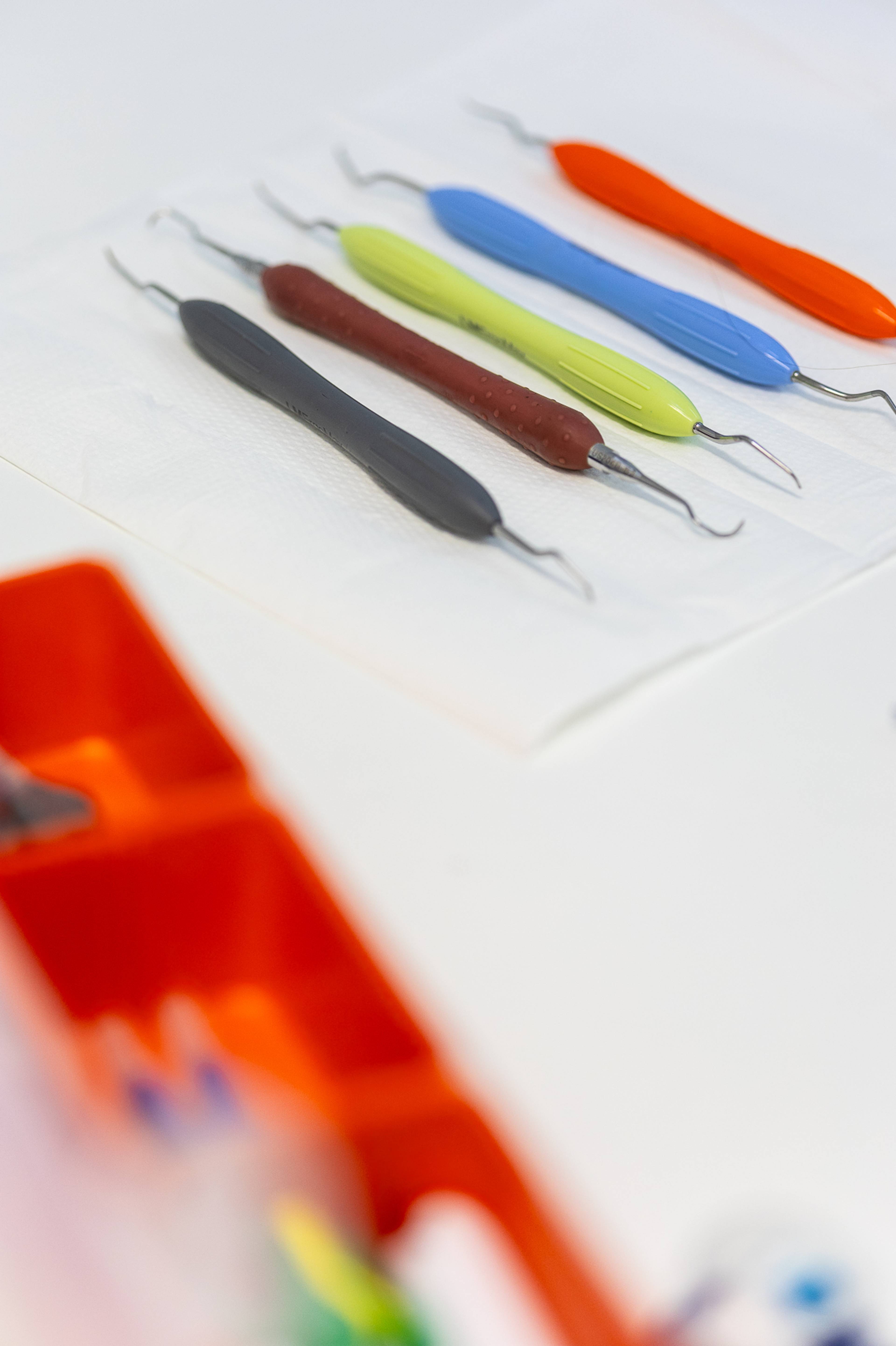 A range of colourful dental instruments laid out on a dentist's table ready to be used