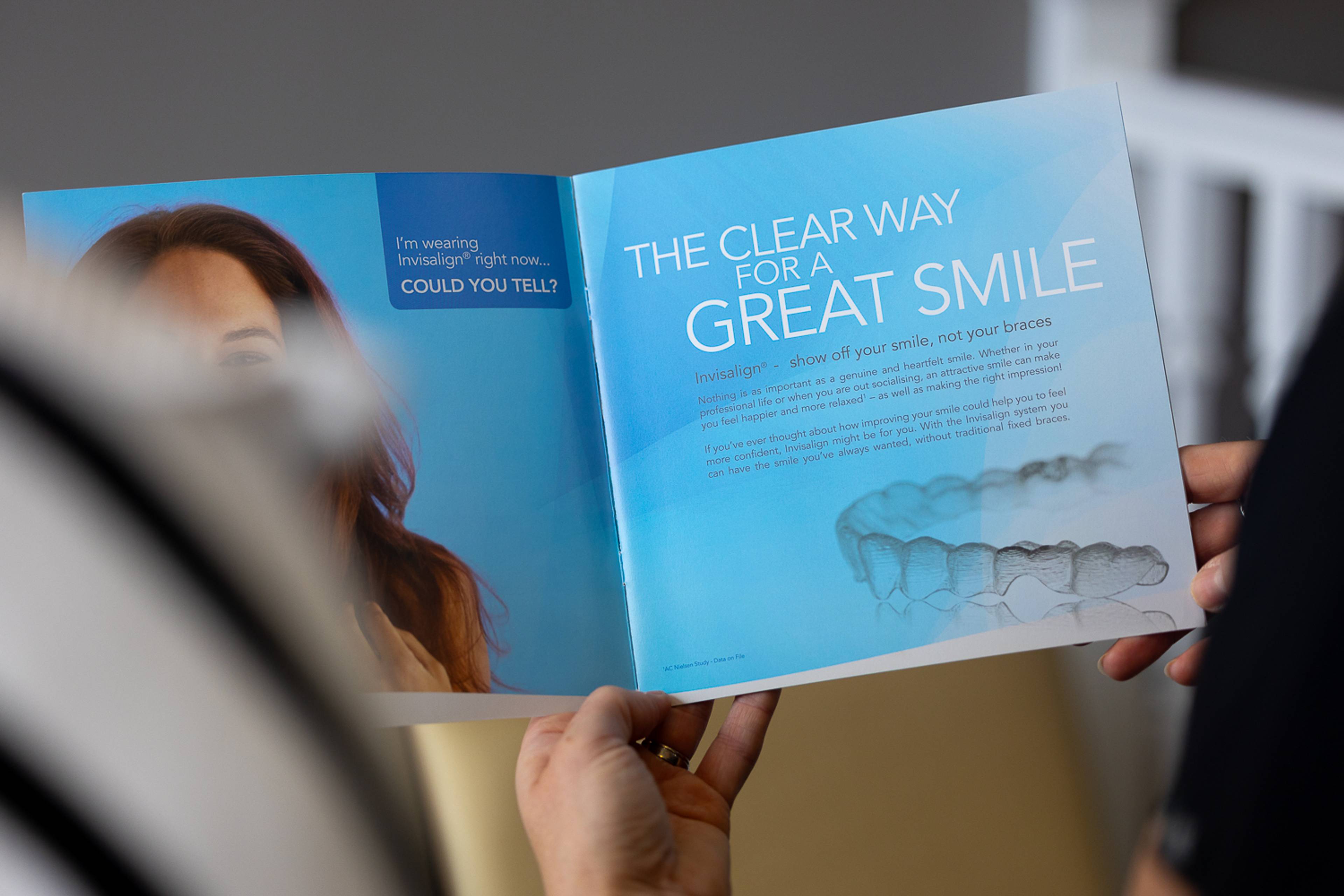 A dentist showing a clear aligners brochure to a patient