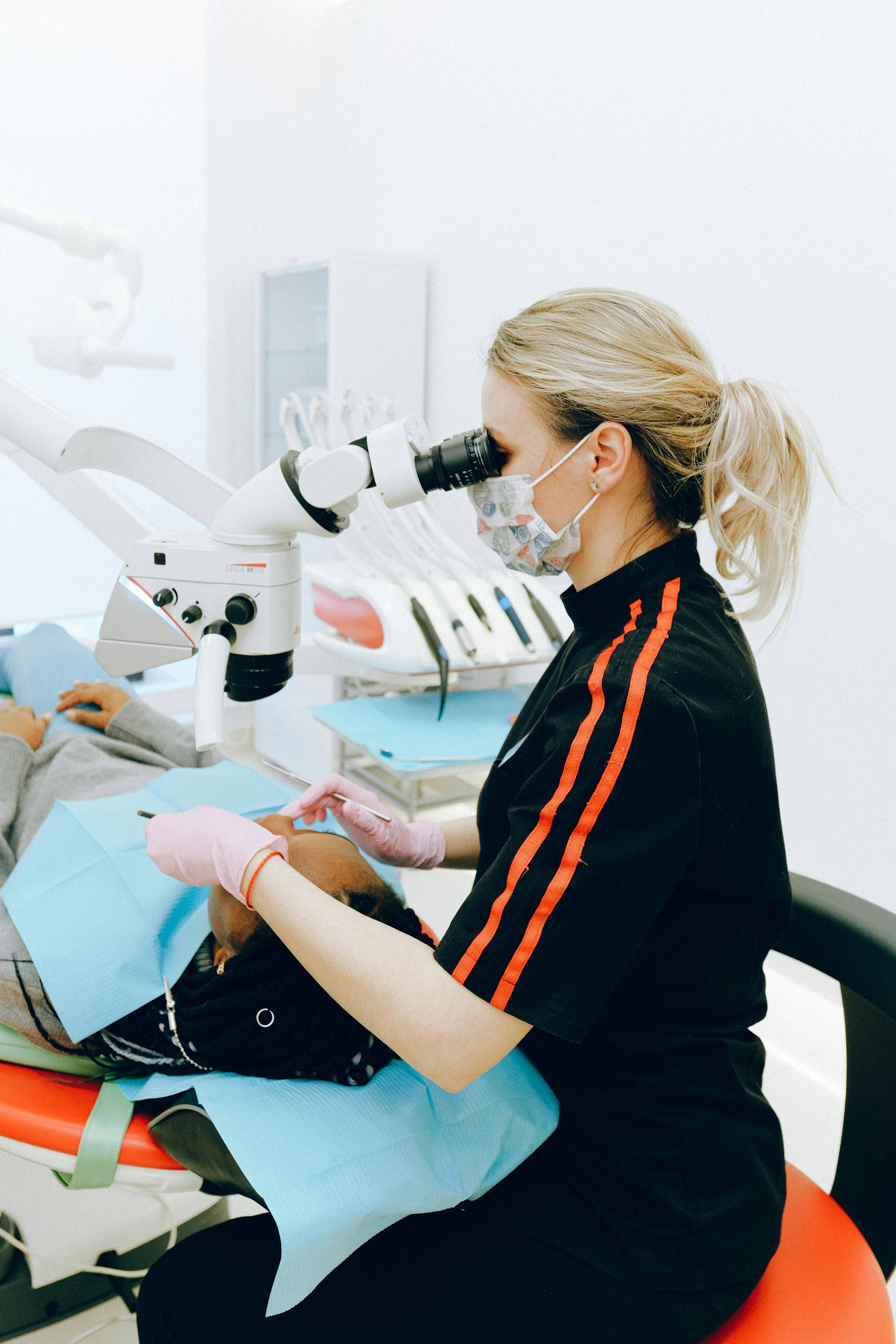 Stock photo of a dentist looking through magnifying equipment at a patient's teeth