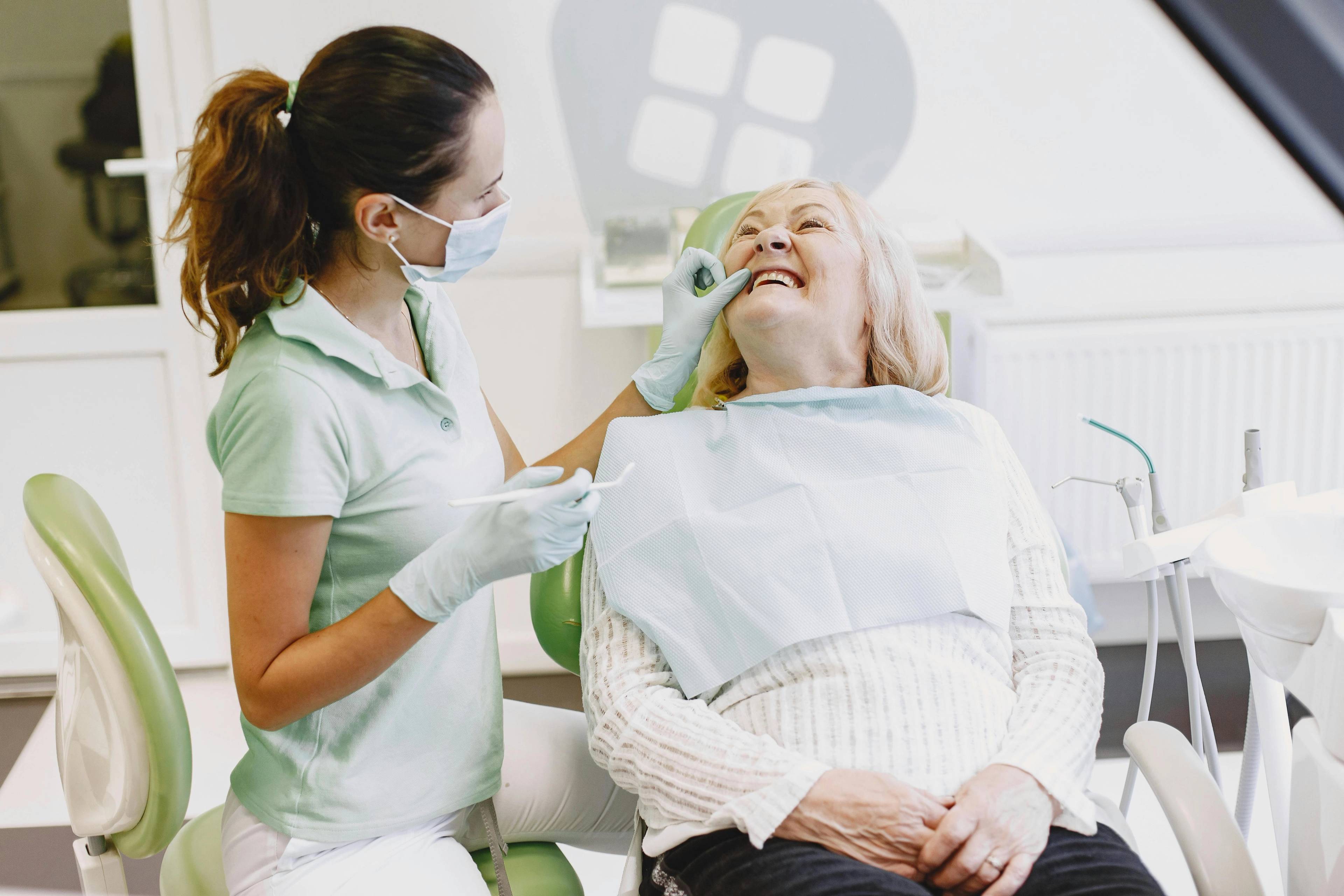 Stock photo of a dentist examining an older female patient's teeth