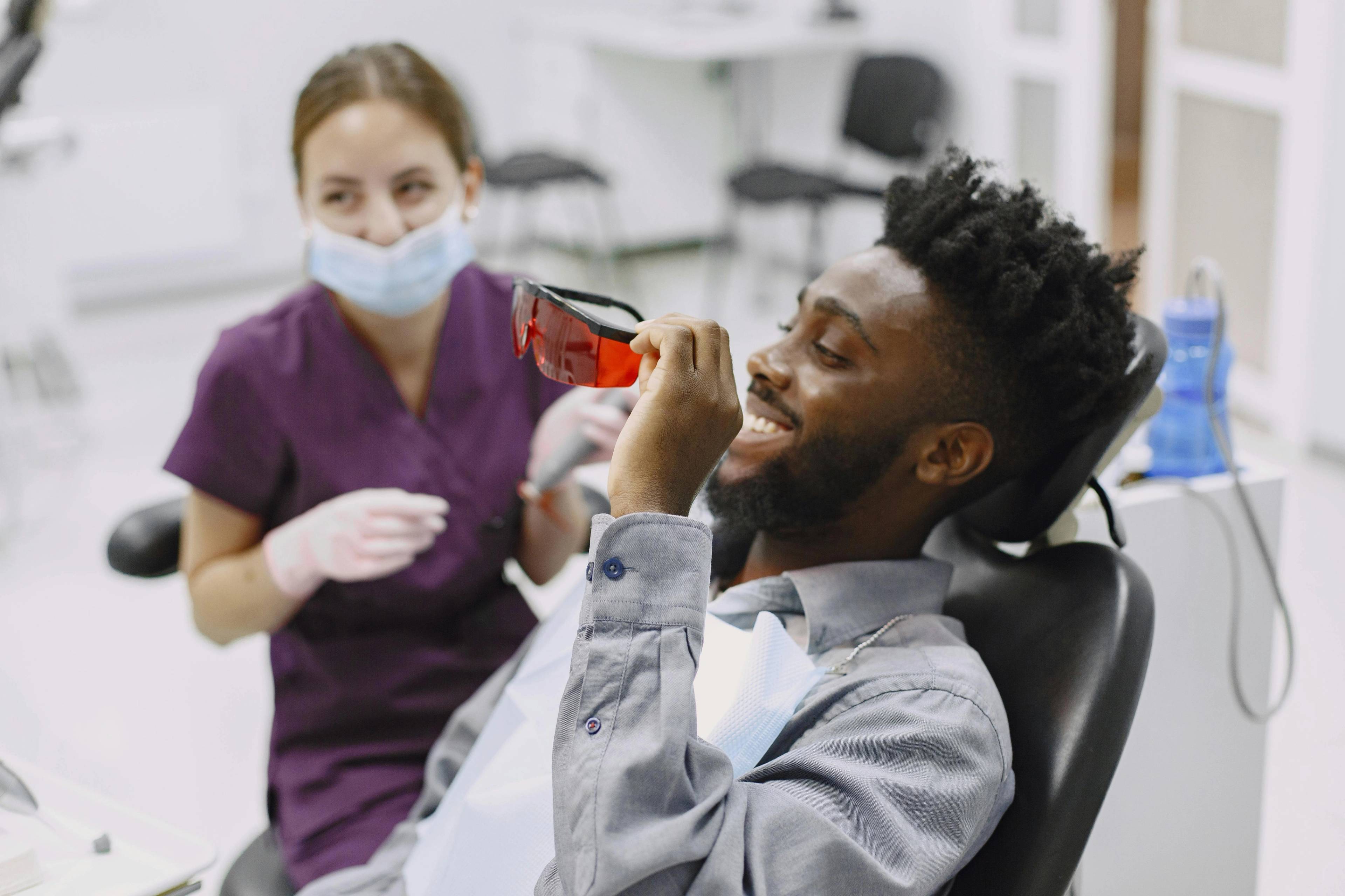 A patient putting on protective glasses before receiving a teeth cleaning