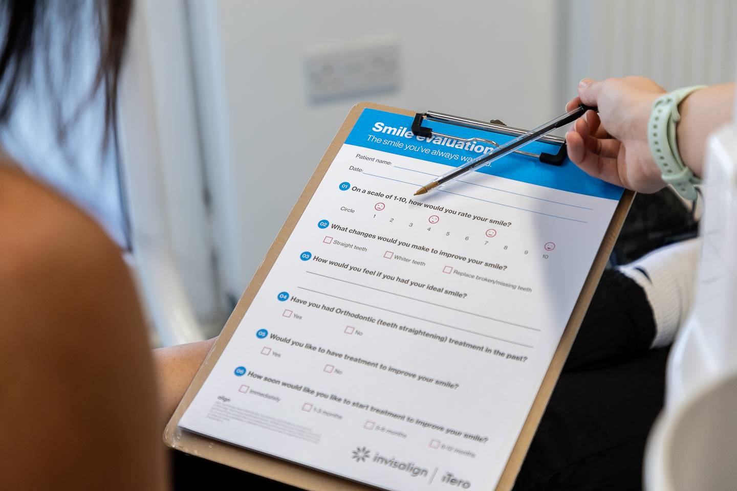 A patient filling out a smile evaluation form during a consultation