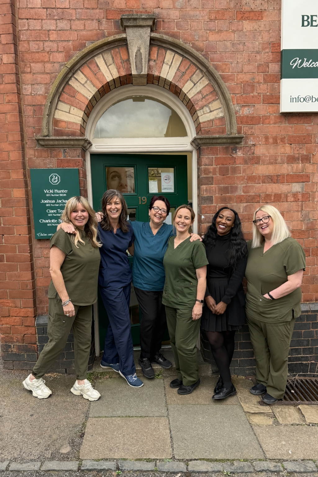 The team at Beacon Park Dental standing at the front of the practice together and smiling
