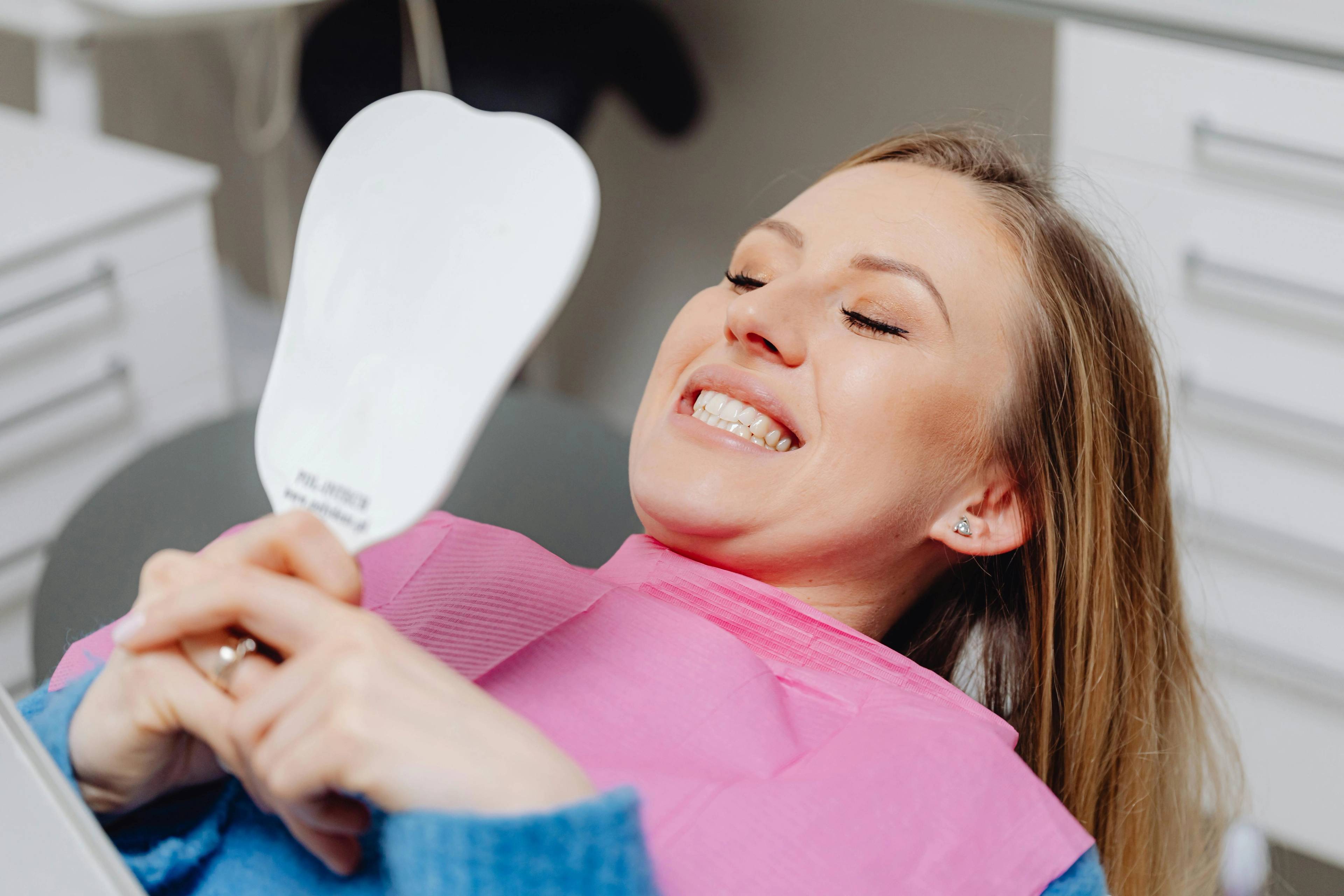 Dental patient smiling in the mirror after treatment