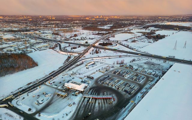 Aerial view of a snowy highway interchange at sunset.