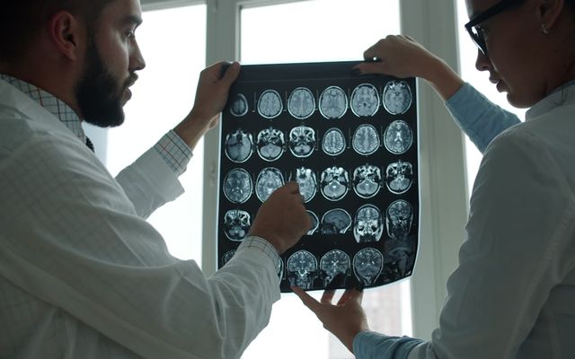 Two doctors examining a brain mri scan together.