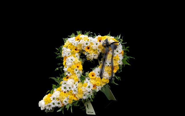 Heart-shaped floral arrangement with yellow and white daisies
