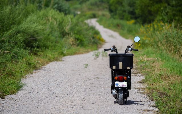 a motorcycle parked on the side of a dirt road