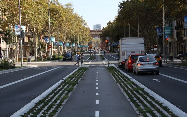 A car driving down a street next to tall buildings