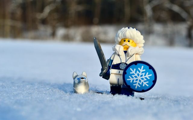 a toy robot with a shield and sword in the snow