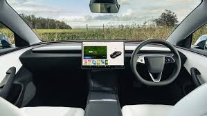 Tesla Model 3 interior cockpit with touchscreen display showing driving interface