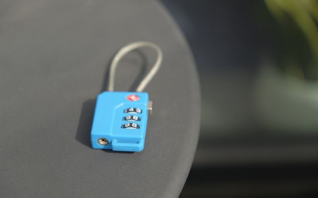 A small blue combination lock rests on a surface.