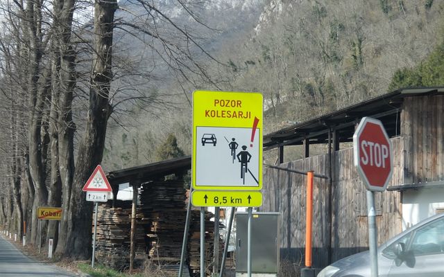 Yellow road sign with bicycle and car symbols