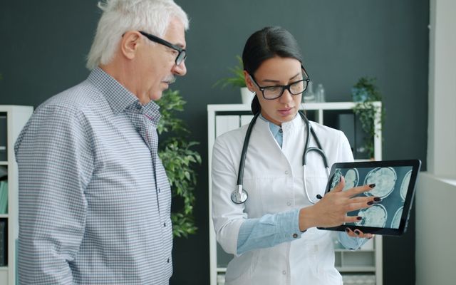 Doctor shows medical scan to elderly patient