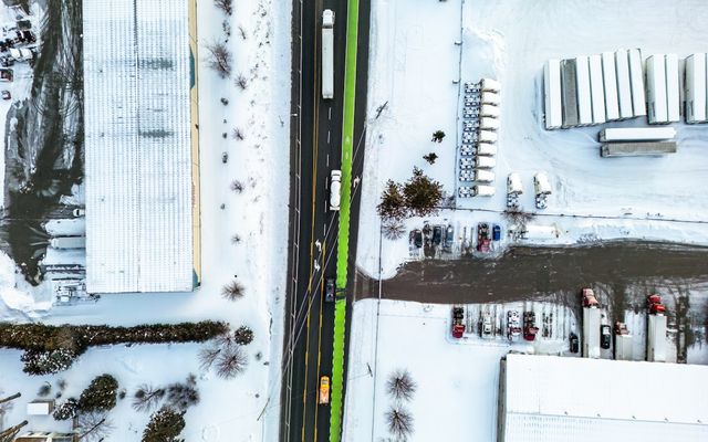Aerial view of a highway with snow-covered surroundings.
