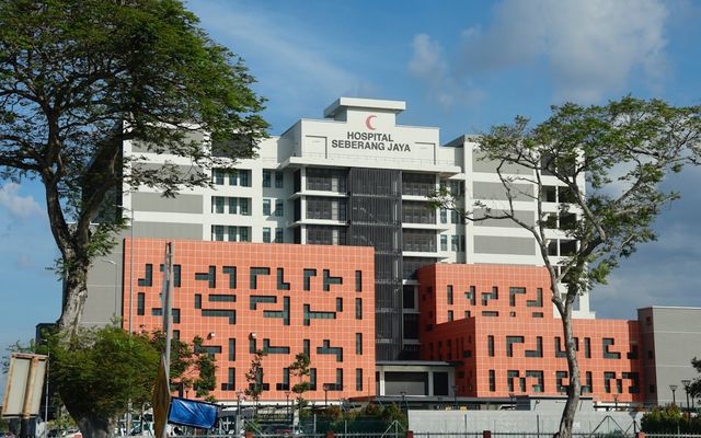 Modern hospital building with red crescent logo.