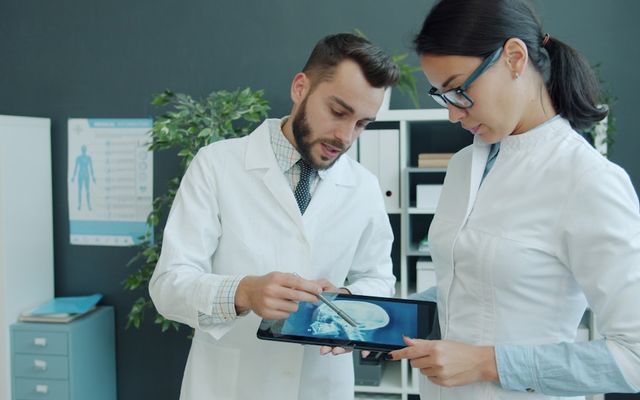 Two doctors looking at a medical scan on tablet