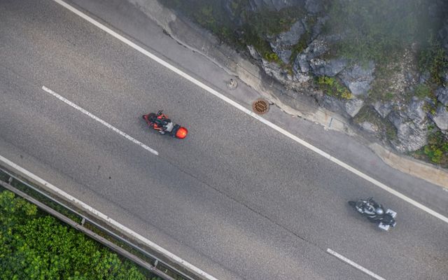 an aerial view of two cars driving down a road