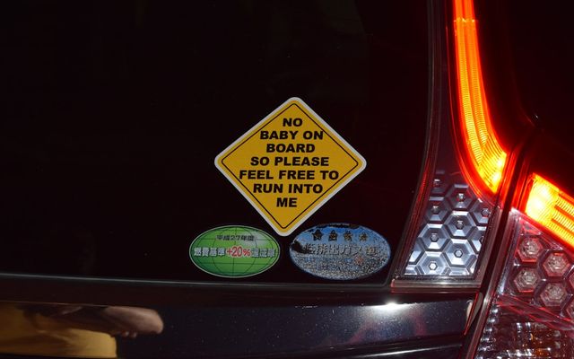 Diamond shaped sticker on car reads 'no baby on board'